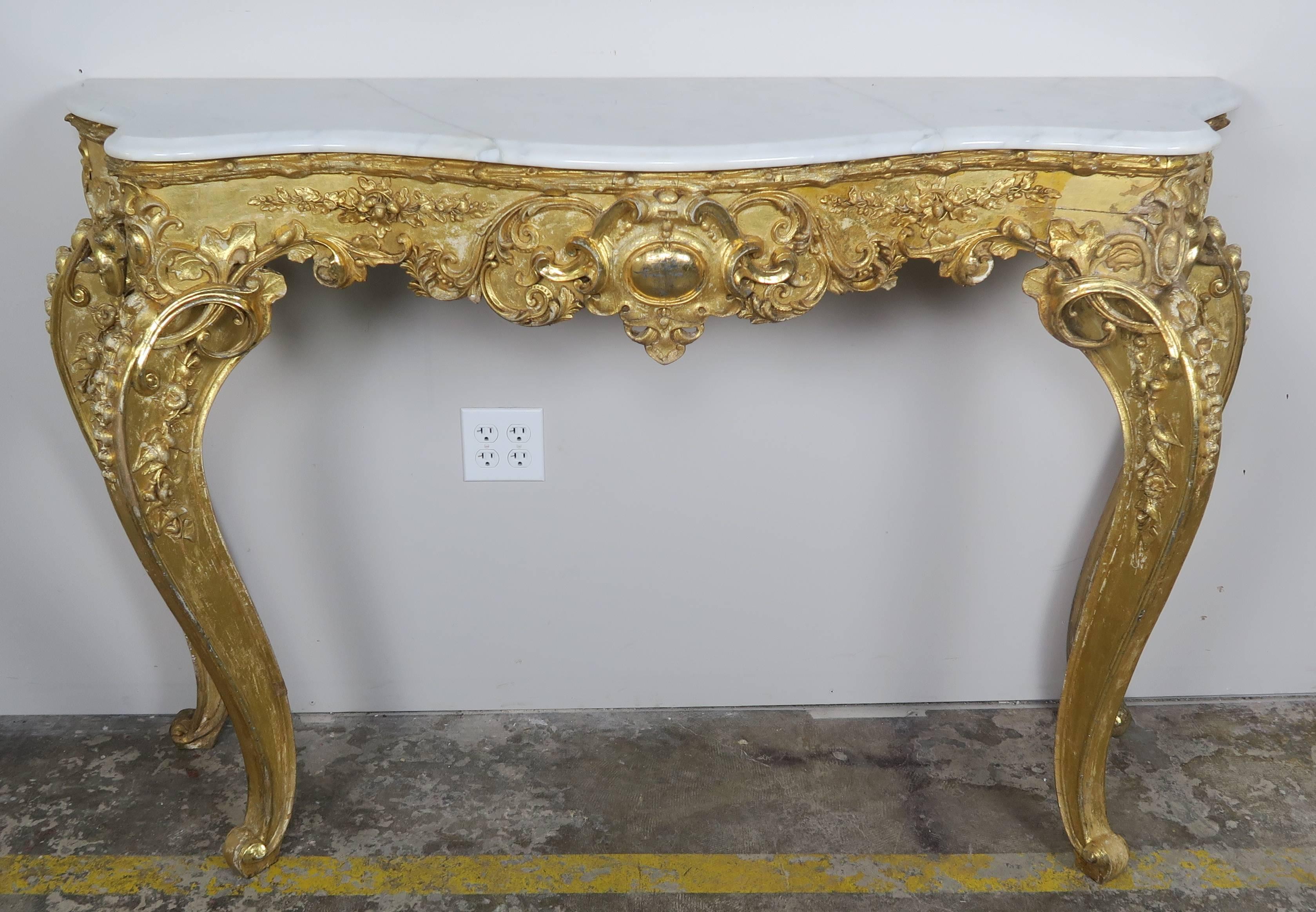 19th century French giltwood carved console with Carrara marble top. The console stands on four cabriole legs. Fine carved details can be seen throughout the piece.