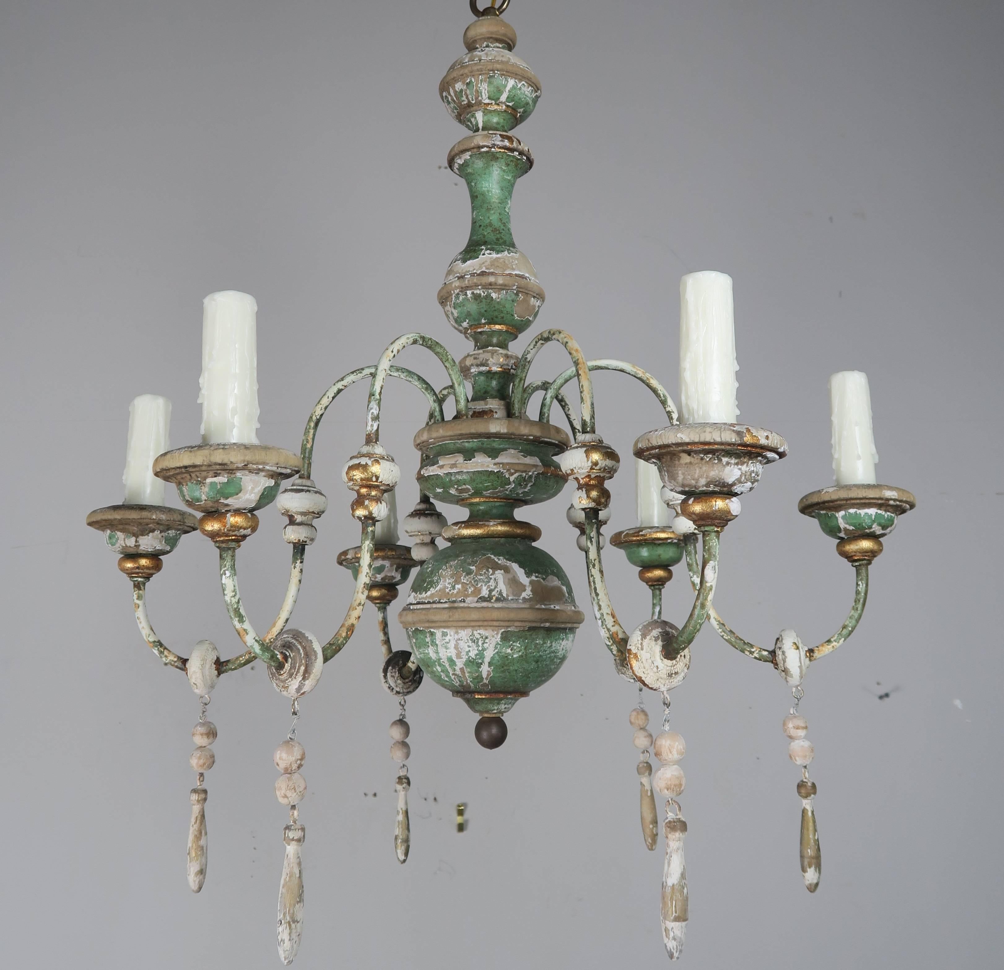 Six-light Italian painted and parcel-gilt chandelier with wood tassel drops. The fixture has been newly rewired with drip wax candle covers. Includes 36