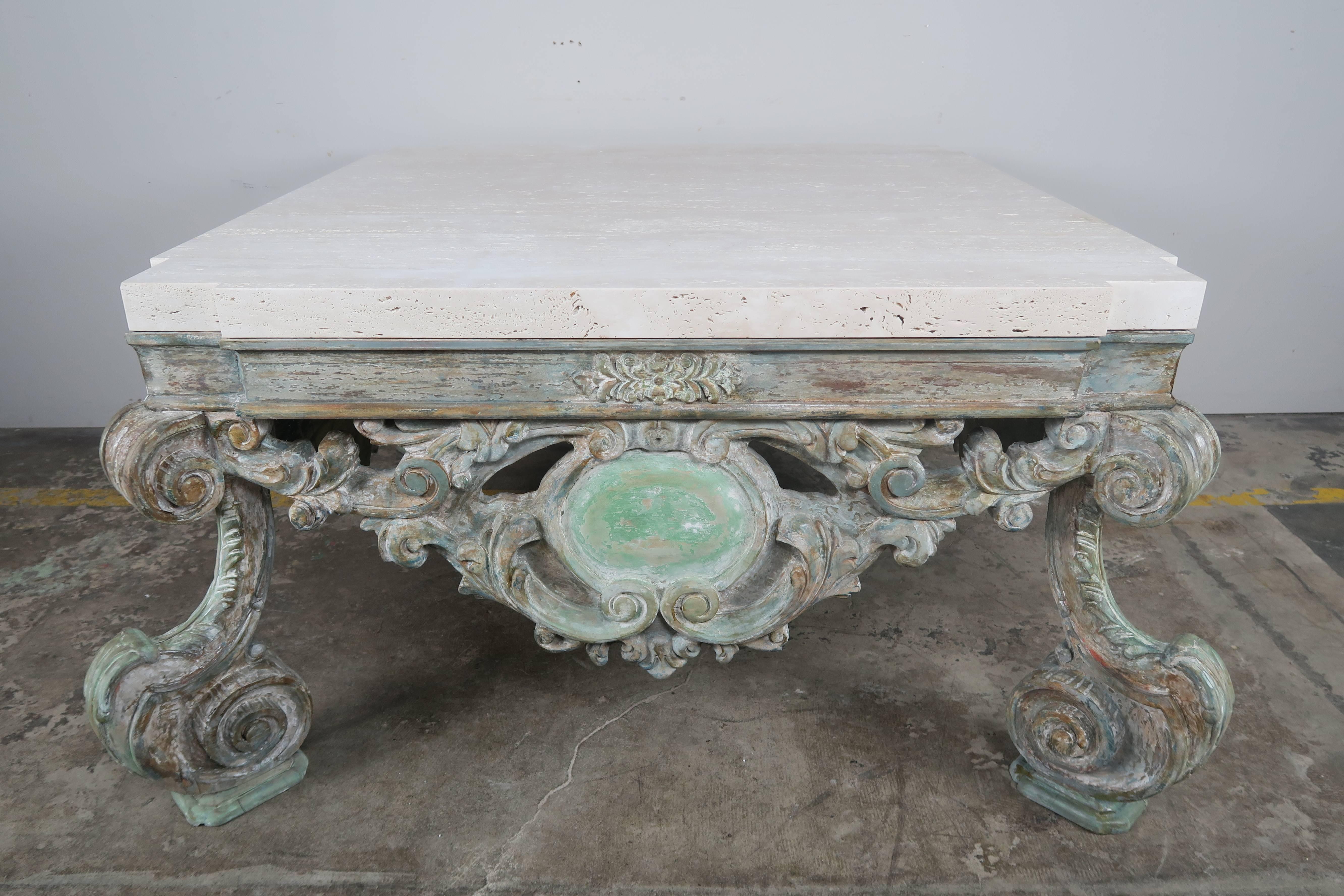 French Louis XV style hand-carved wood coffee table standing on four scrolled legs. All four sides have beautiful intricate carvings depicting swirling acanthus leaves around a center cartouche. Worn paint remains throughout. Measures: 2