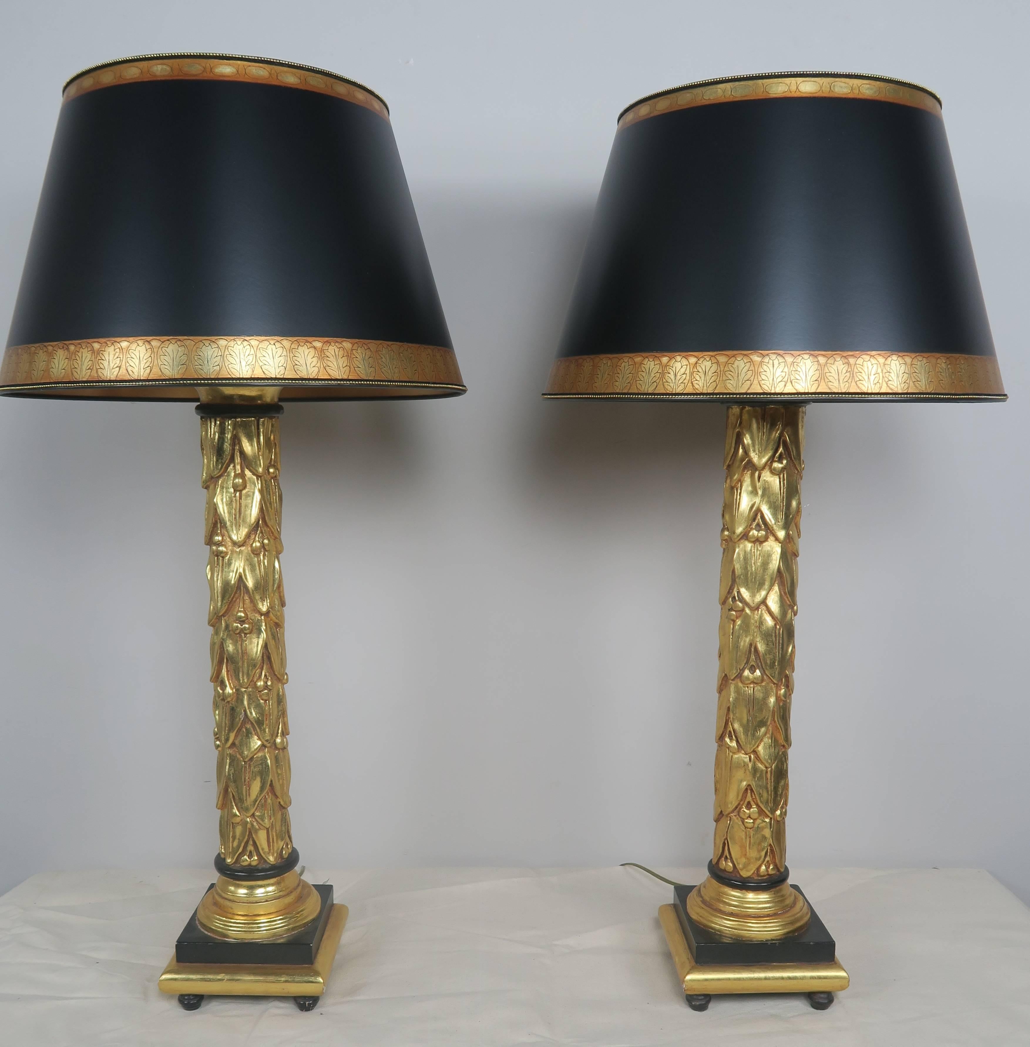 Neoclassical style 22-karat gold leaf and black painted lamps with hand-painted black and gold parchment shades. These lamps were originally made by Traditional Imports in the mid-late 20th century. The lamps have been newly rewired and are in