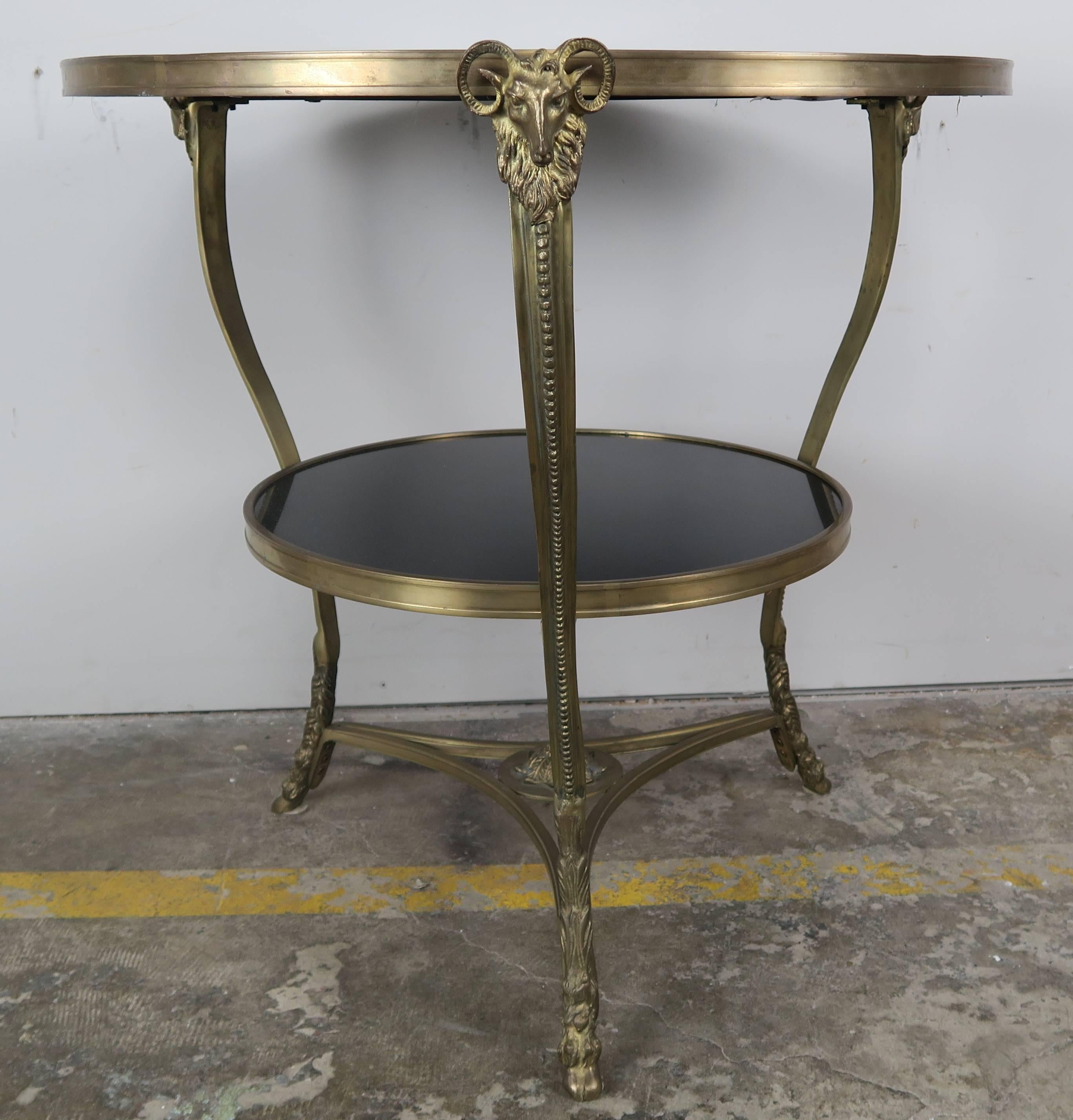 French cast bronze and black stone two-tier tripod gueridon table with ram's head detail.