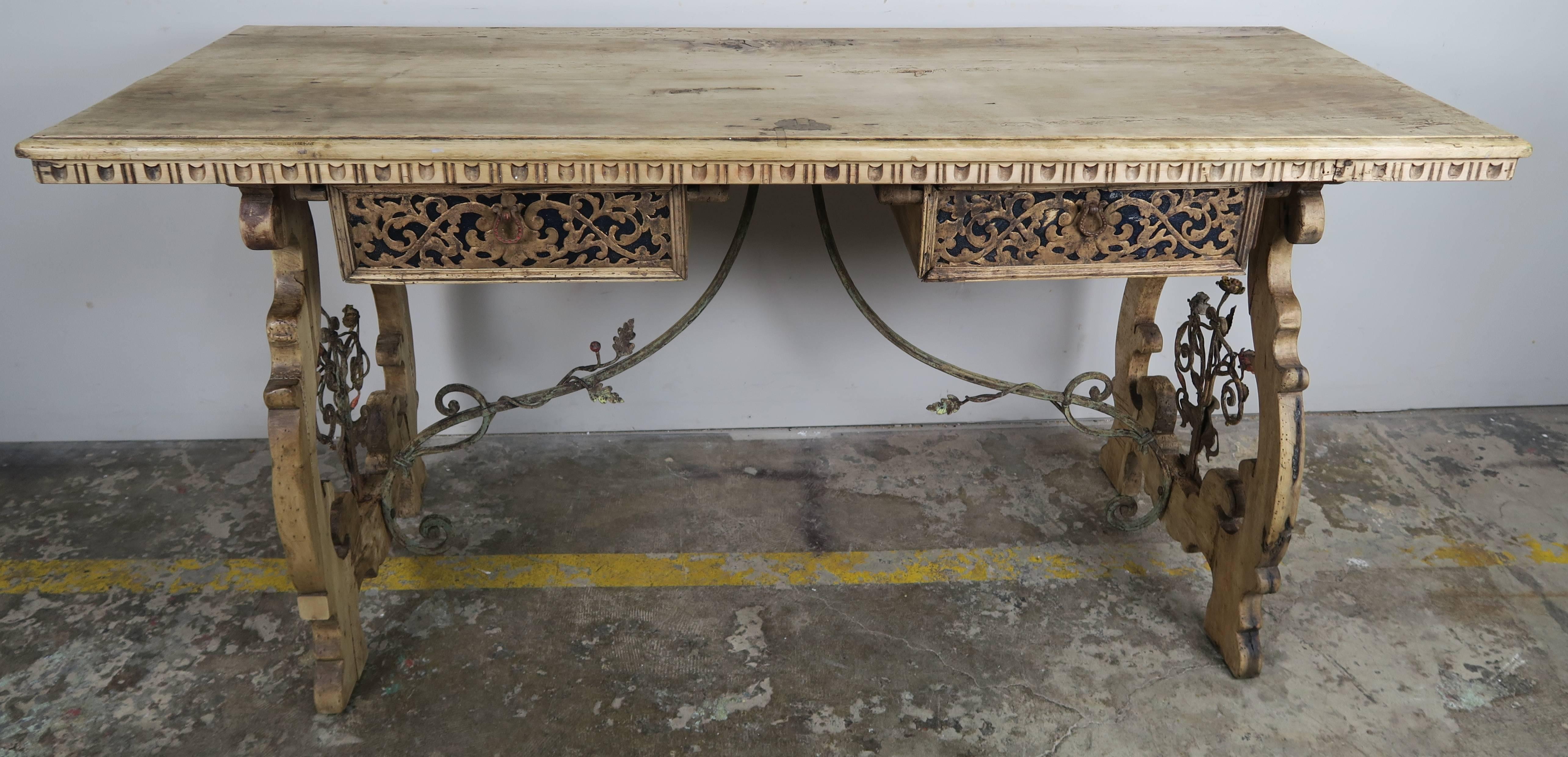 19th century bleached walnut and wrought iron desk with two drawers. Beautiful unique brass metalwork on both drawers. A wrought iron stretcher connects two pedestals depicting a hand-wrought iron bouquet of flowers at each end.