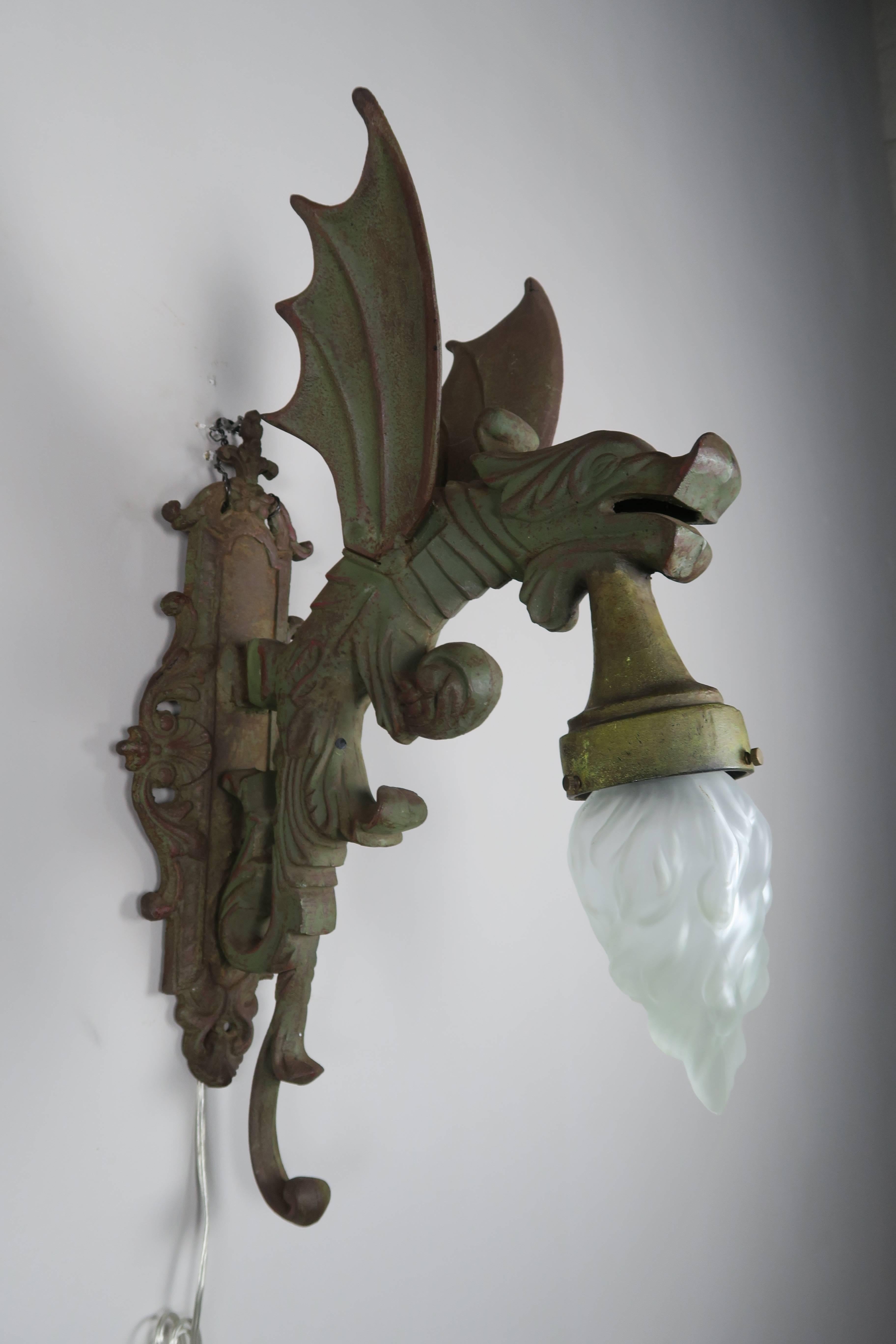 Pair of 1940s green painted French Gothic style dragon sconces with glass flame shaped bulbs. The sconces have been newly wired and are ready to install.
