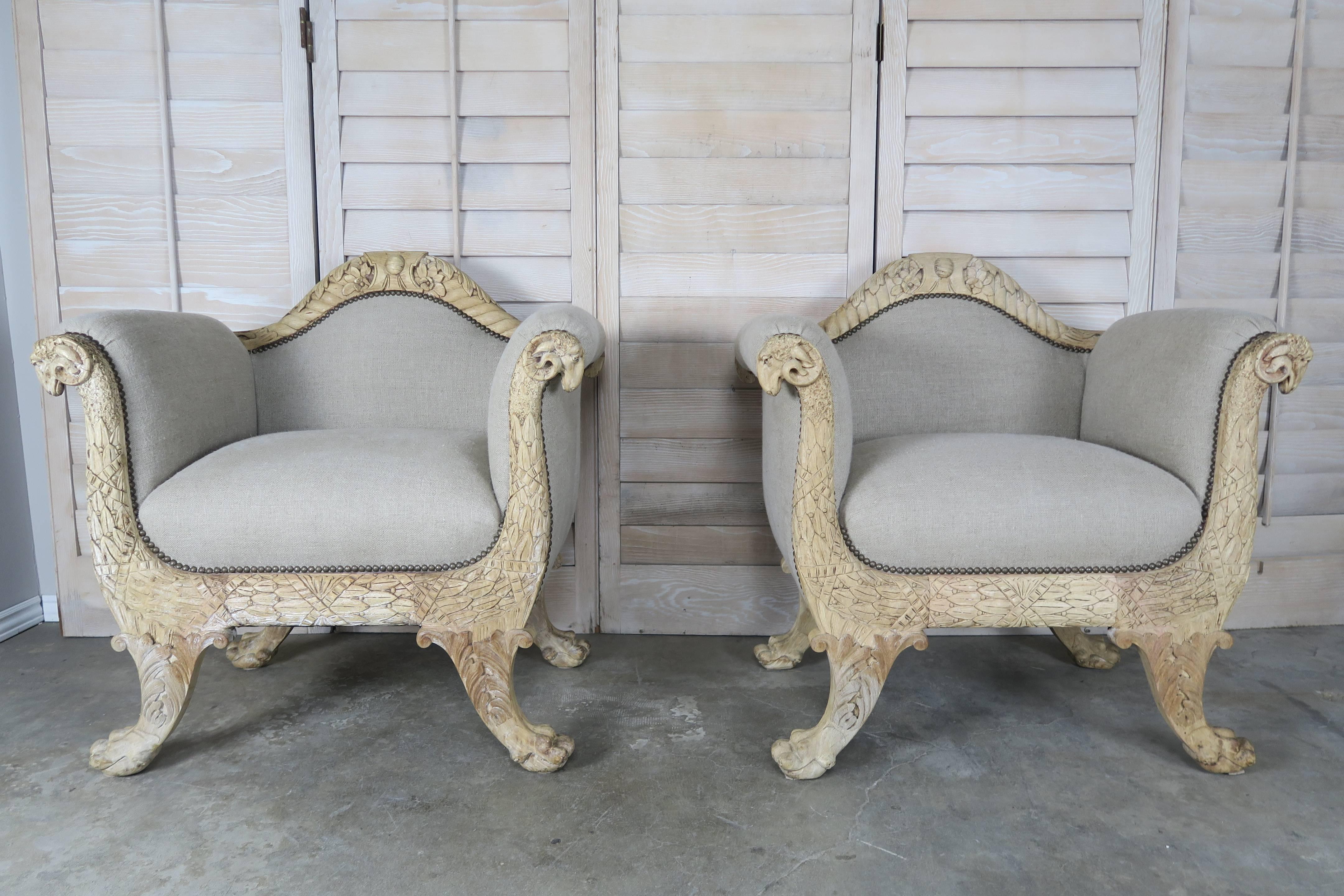 Pair of 19th century French beautifully carved armchairs depicting rams heads, angel wings, acanthus leaves and much more. The chairs stand on lion paw feet and have a beautiful bleached walnut finish. The chairs are newly upholstered in natural