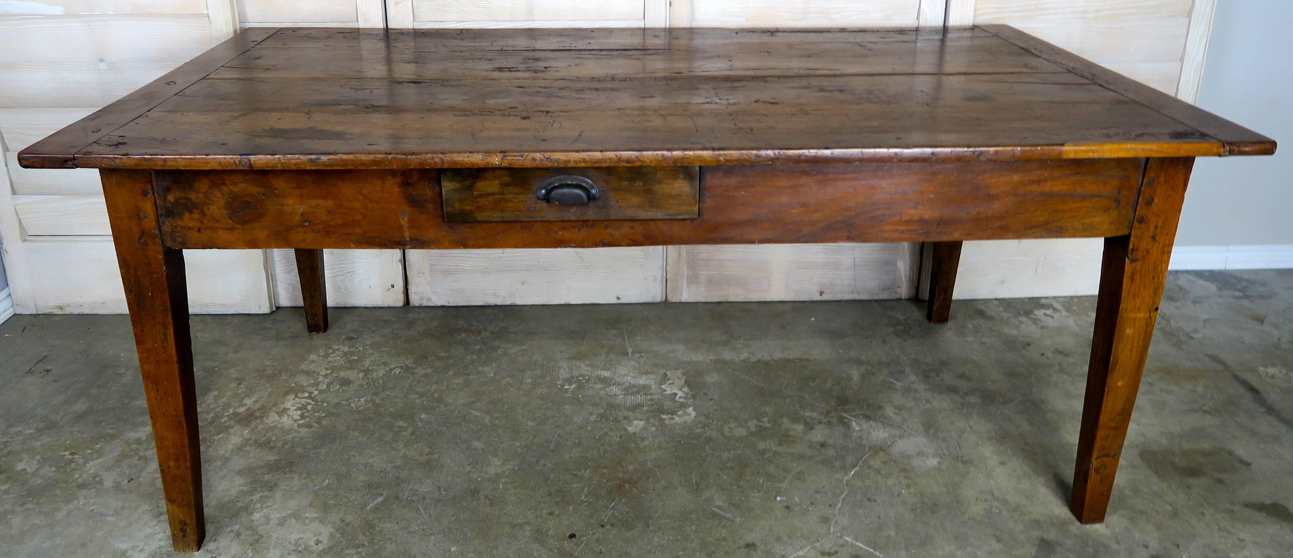 19th century cheerywood dining table that was reduced to a coffee table height. The table stands on four tapered legs and has a single drawer.