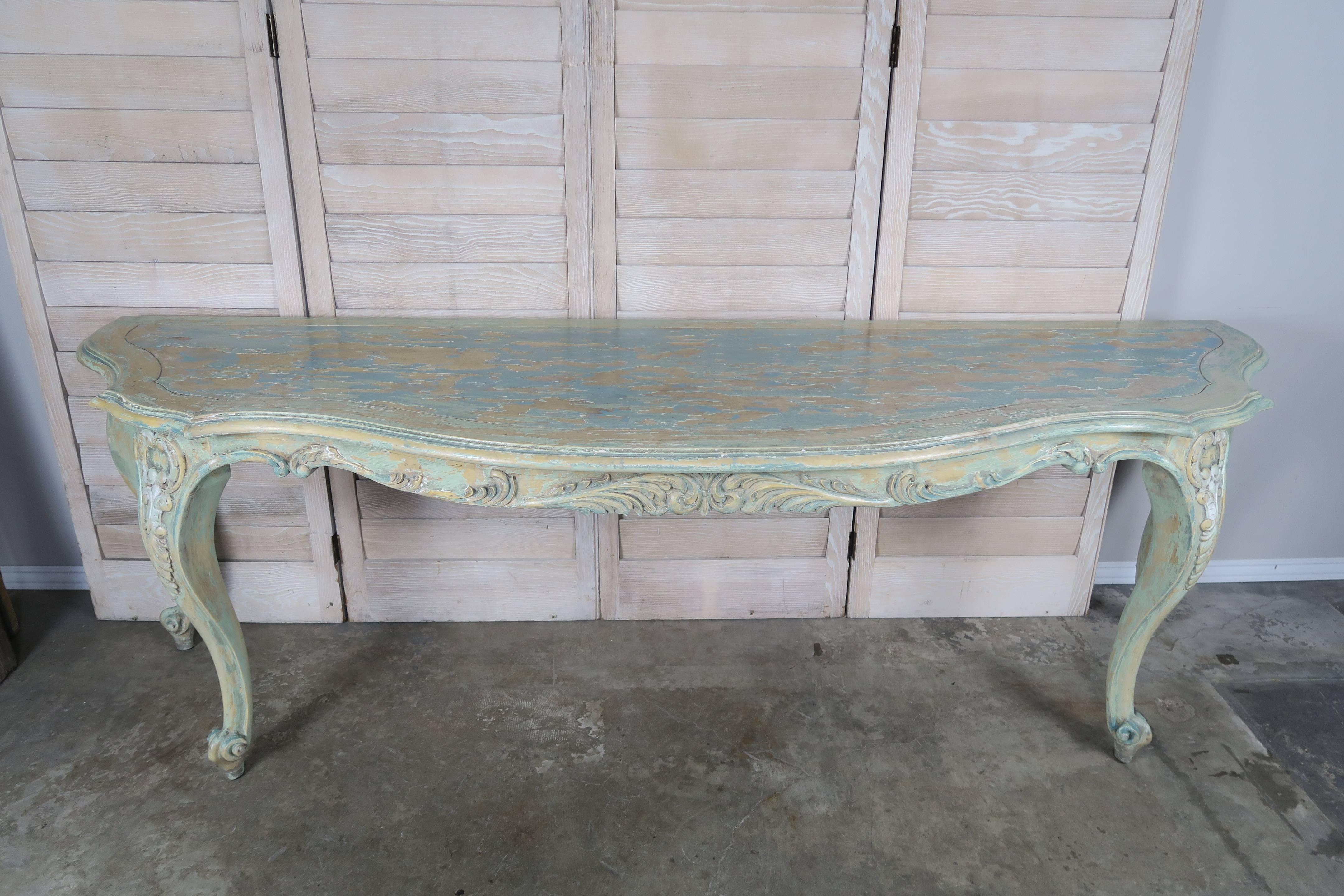 French carved serpentine shaped Louis XV style sea foam green painted console standing on four cabriole legs ending in rams head feet.