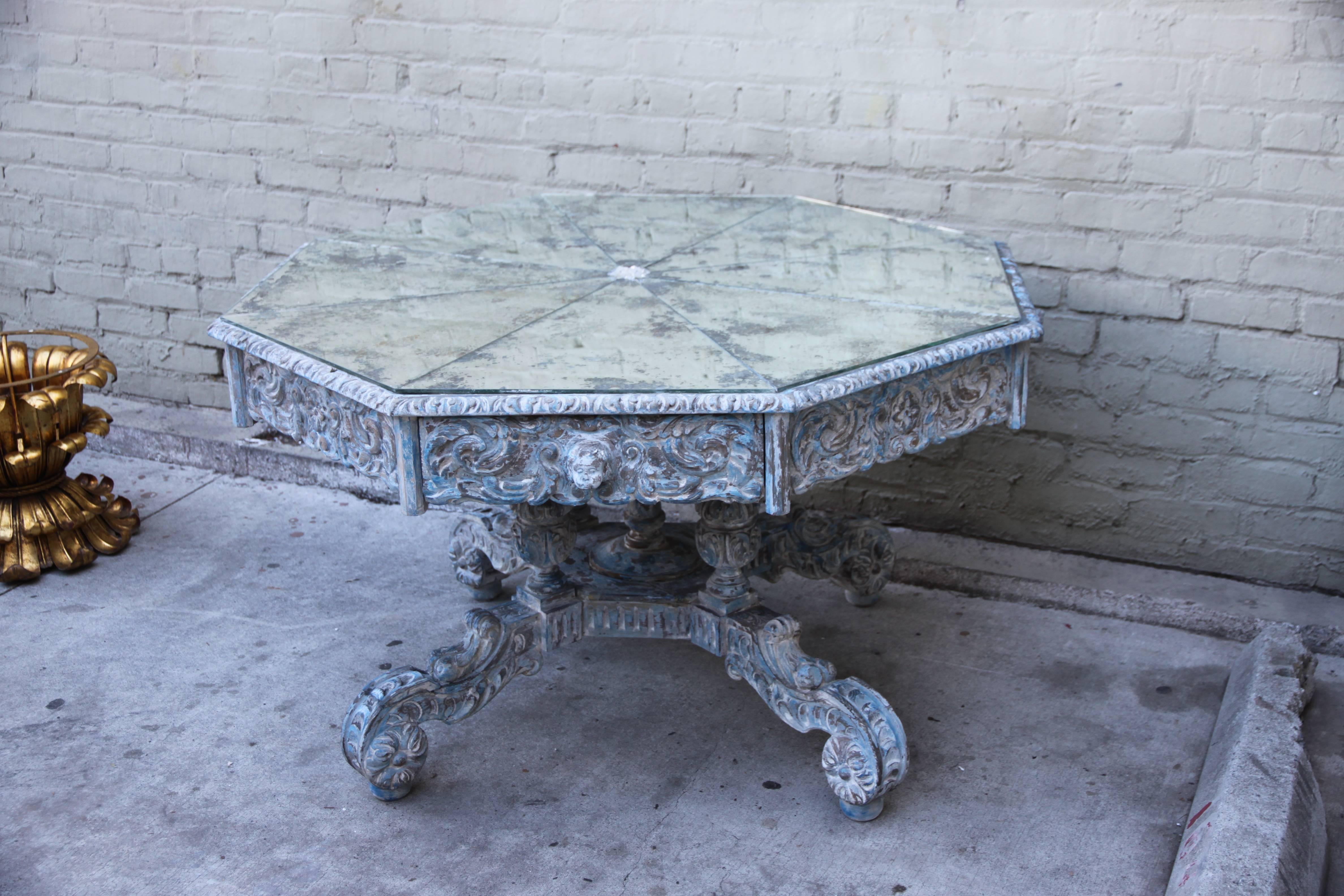 Spanish antique painted library table. Drawers on four sides with hand-carved cherub knobs. Antique mirrored octagonal top. This table can be used for both dining and as a centre table.