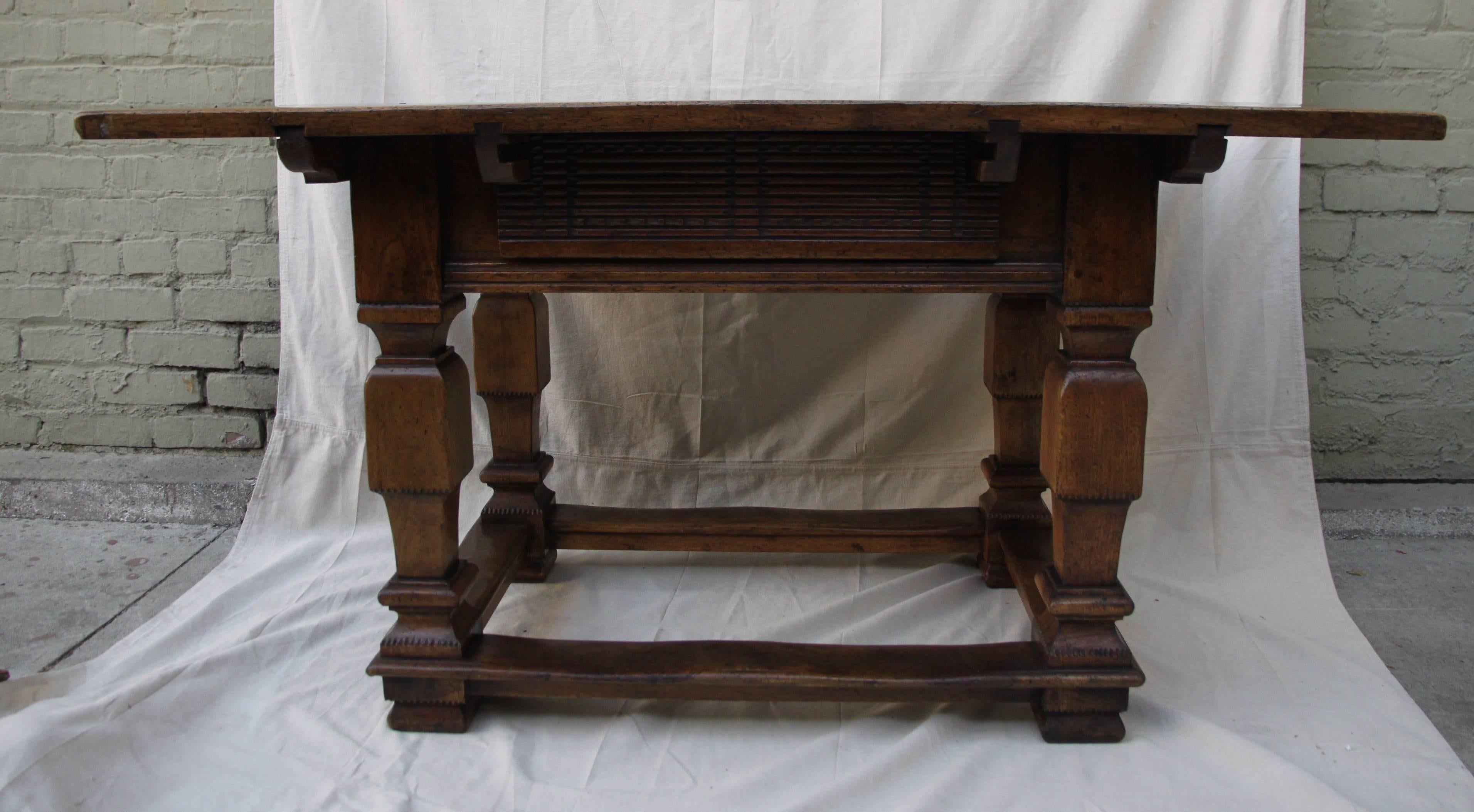 Italian Tuscan style walnut table with center drawer and bottom stretcher.