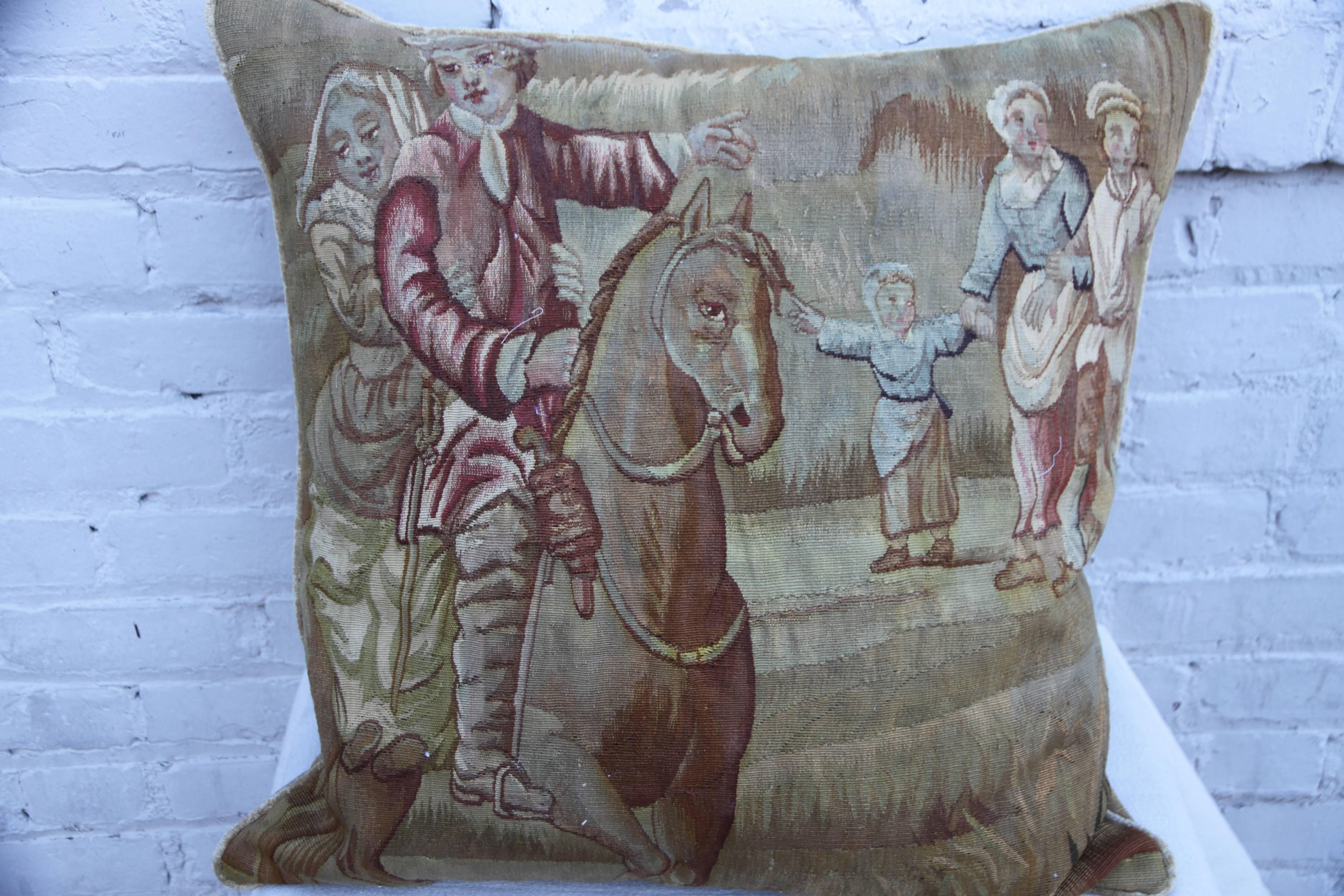 19th century French figural tapestry pillow depicting a couple on horseback with a family of onlookers in the background. Soft gold colored linen velvet back with self cord detail. Down insert, sewn shut.