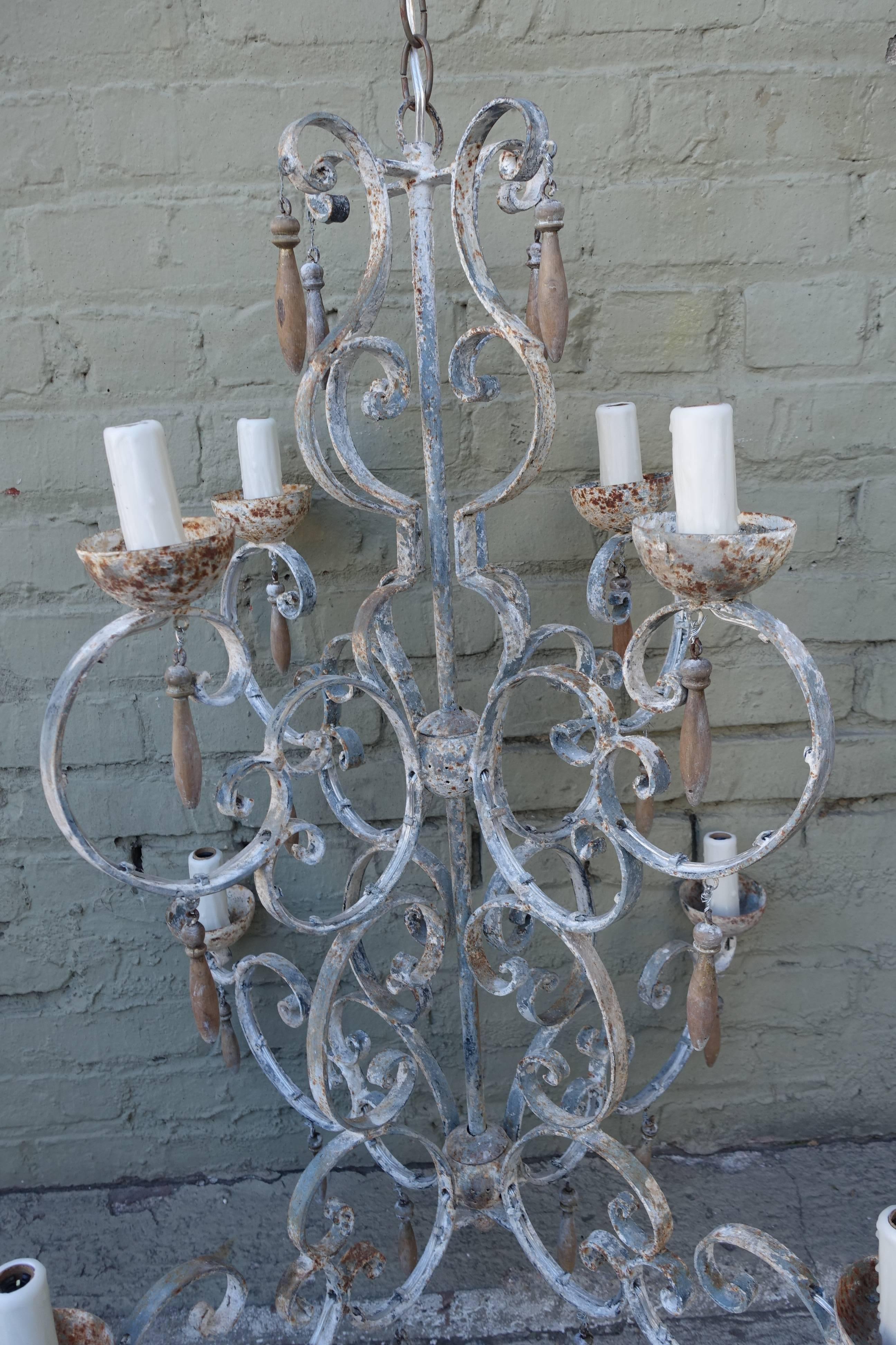 Eight-light painted wrought iron chandelier that has been newly rewired with chain and canopy included. Wood tassels throughout.