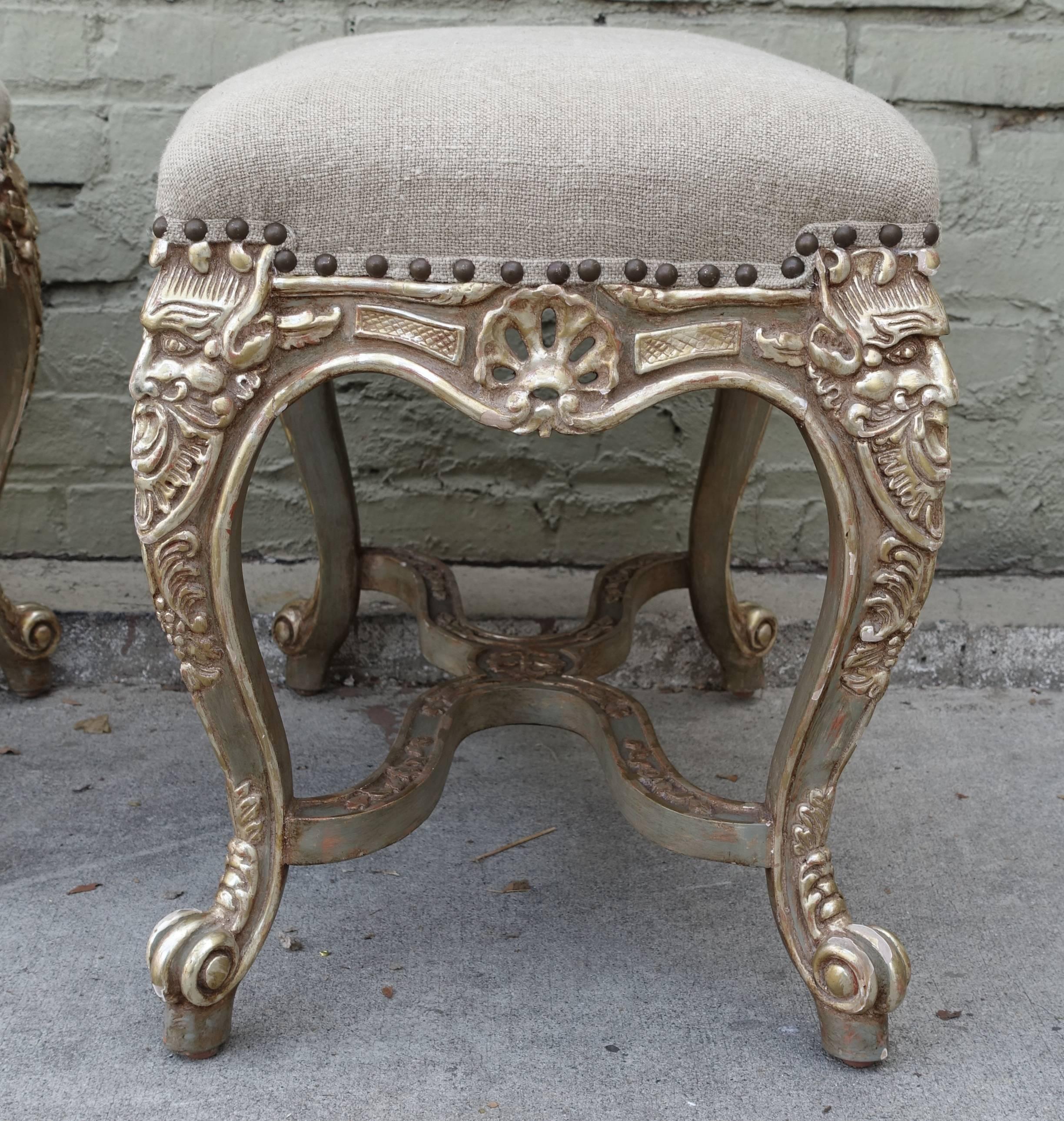 Pair of French carved Rococo style painted and silver gilt benches upholstered in Belgium linen with nailhead trim detail.