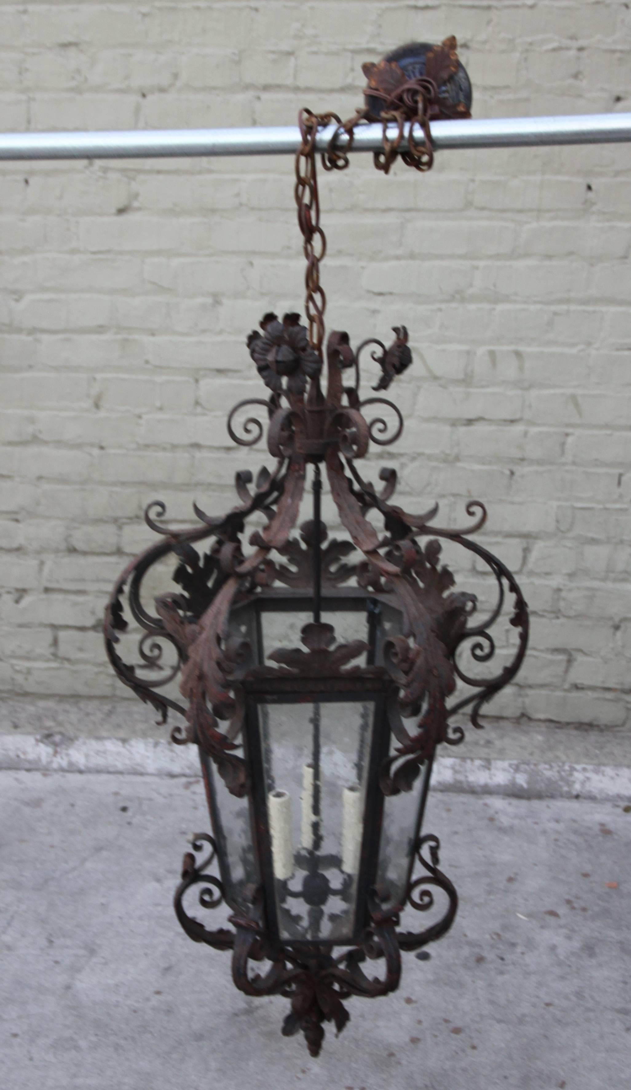 Spanish hand-wrought iron lantern with scrolled acanthus leaf details and flowers throughout. Newly wired with three lights. Includes chain and canopy.