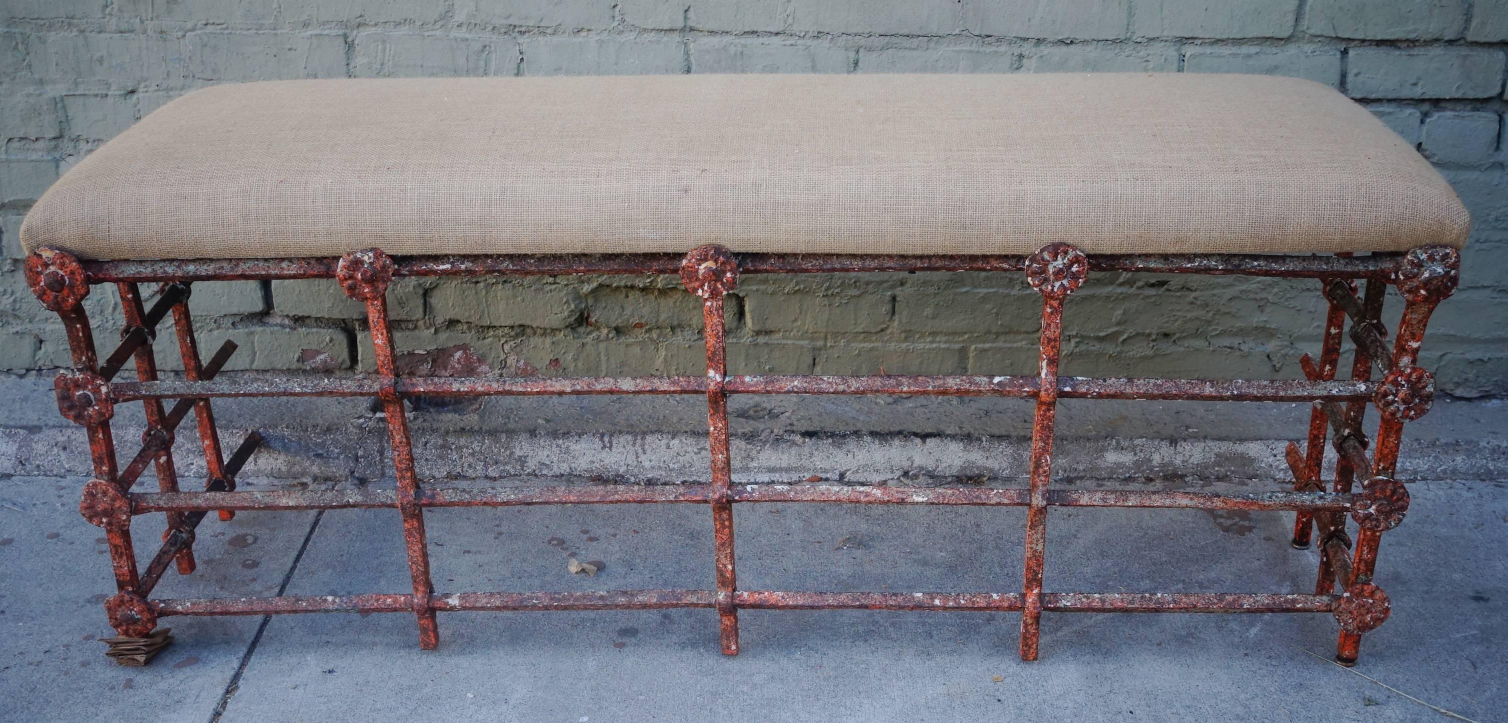 18th century Spanish painted wrought iron bench with floral rosettes throughout. Newly upholstered in Burlap textile.