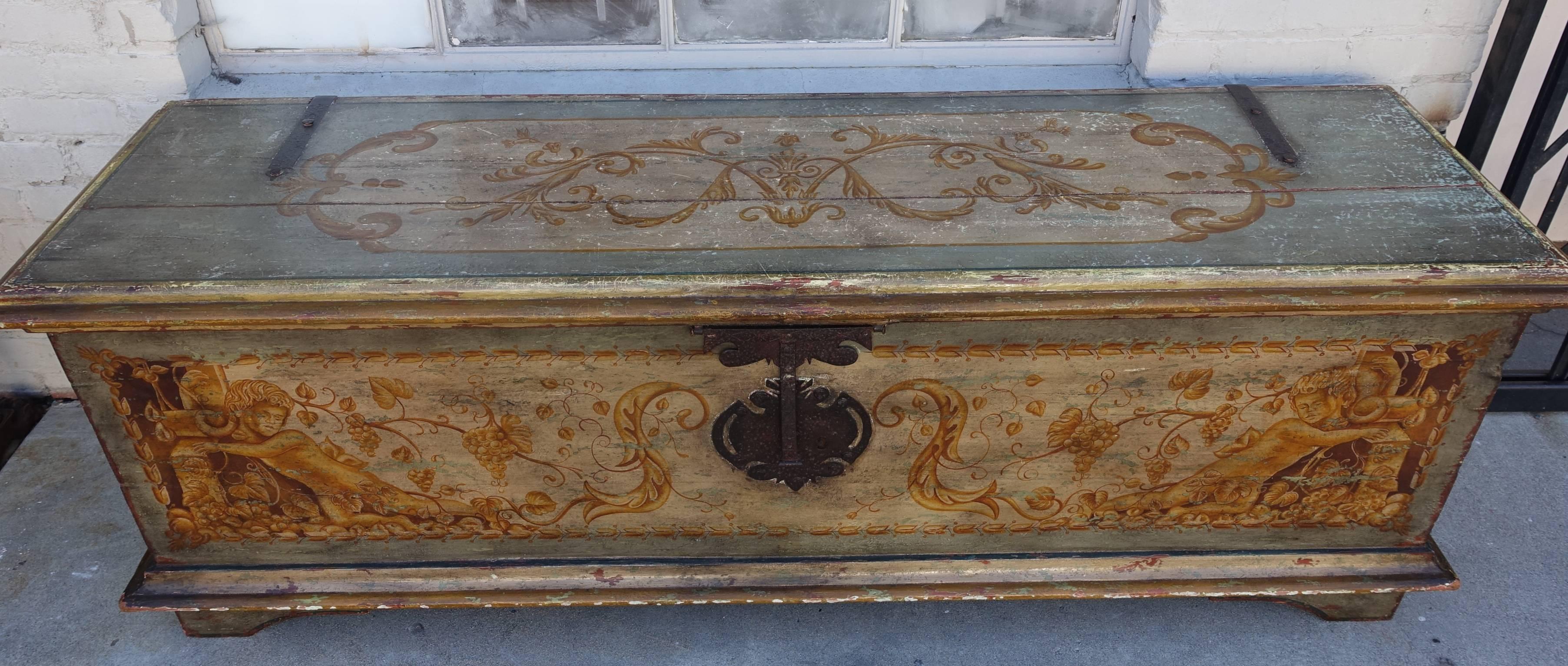 Italian hand-painted wood and iron trunk decorated with cherubs and swirling acanthus leaves throughout.