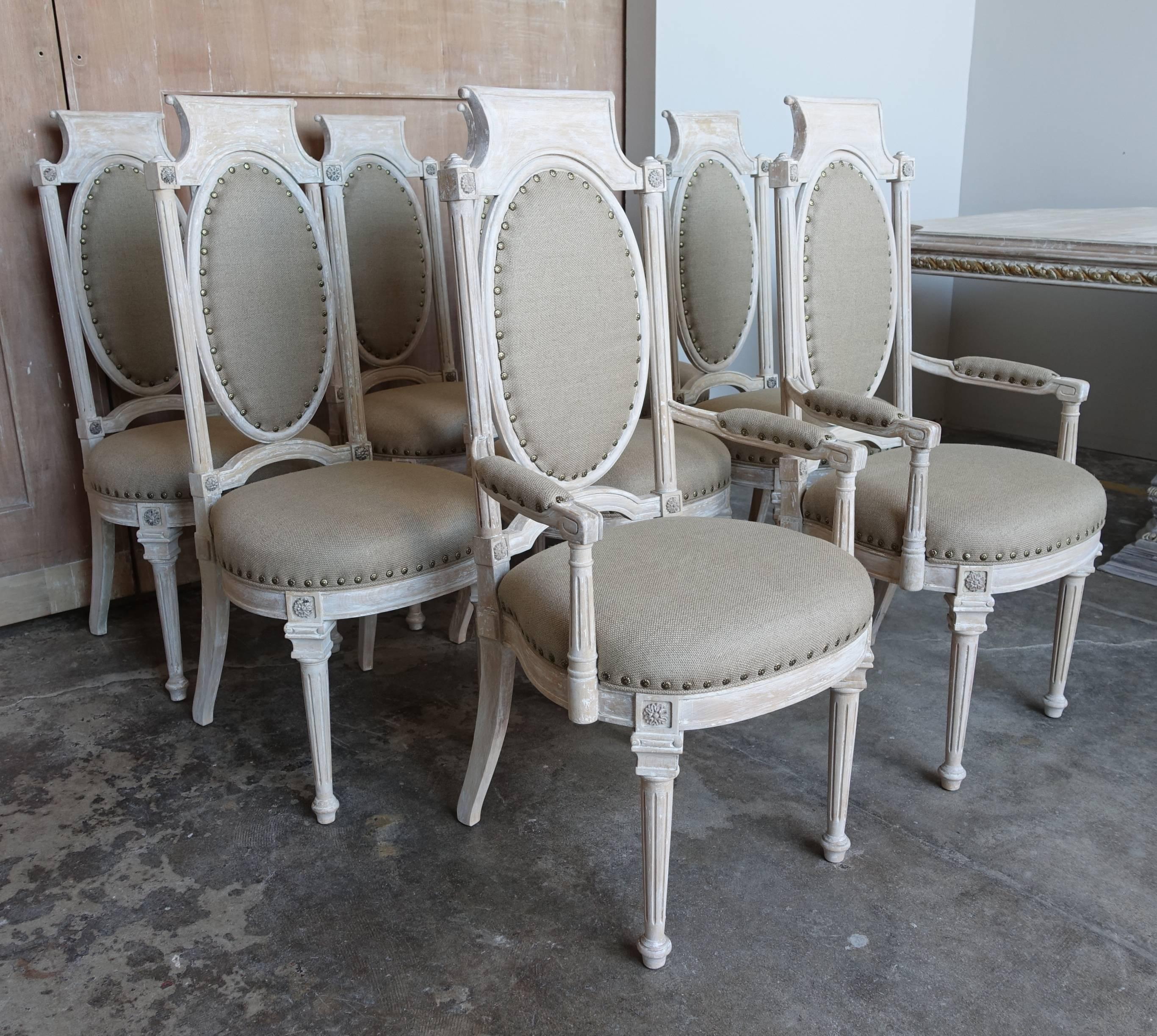 Set of eight Italian painted neoclassical style dining chairs newly upholstered in Belgium linen with floral nailhead trim detail.

 