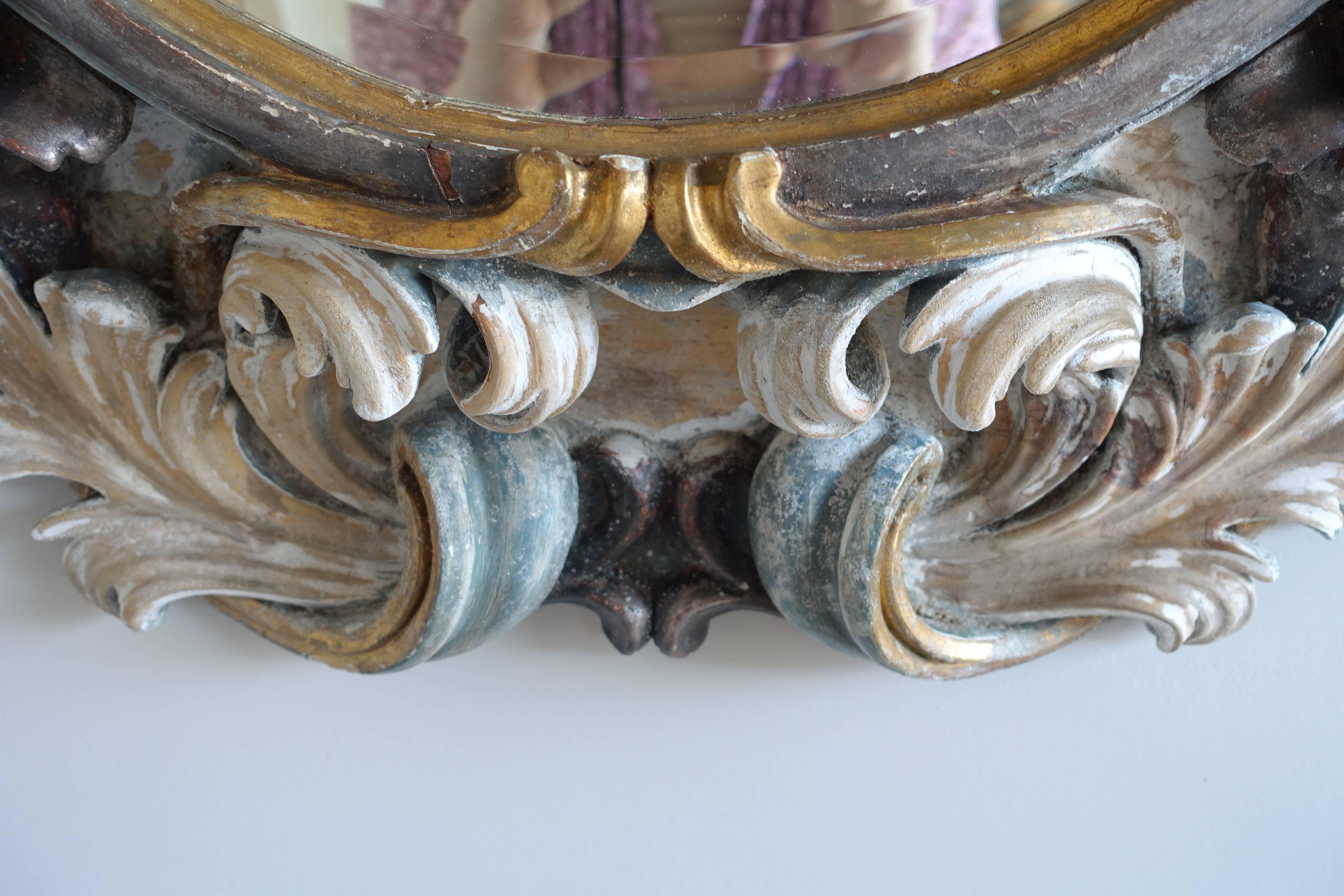 Italian Rococo style painted and parcel-gilt (silver and gold) finely hand-carved wood mirror with swirling acanthus leaves and grapes throughout.