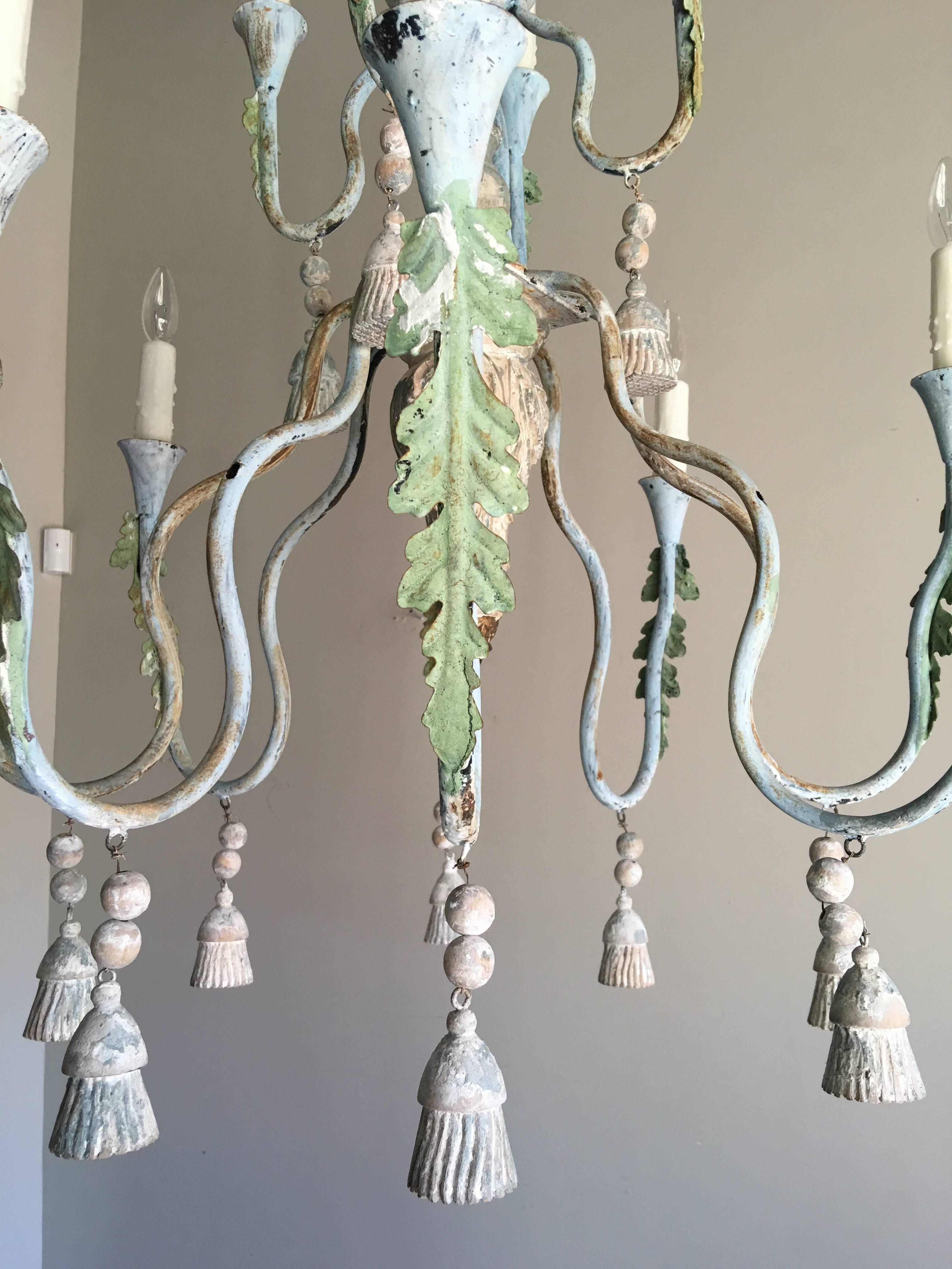 12 light wood and iron painted chandelier with carved wood tassels hanging throughout. This fixture has been newly wired with chain and canopy included. Drip wax candle covers.