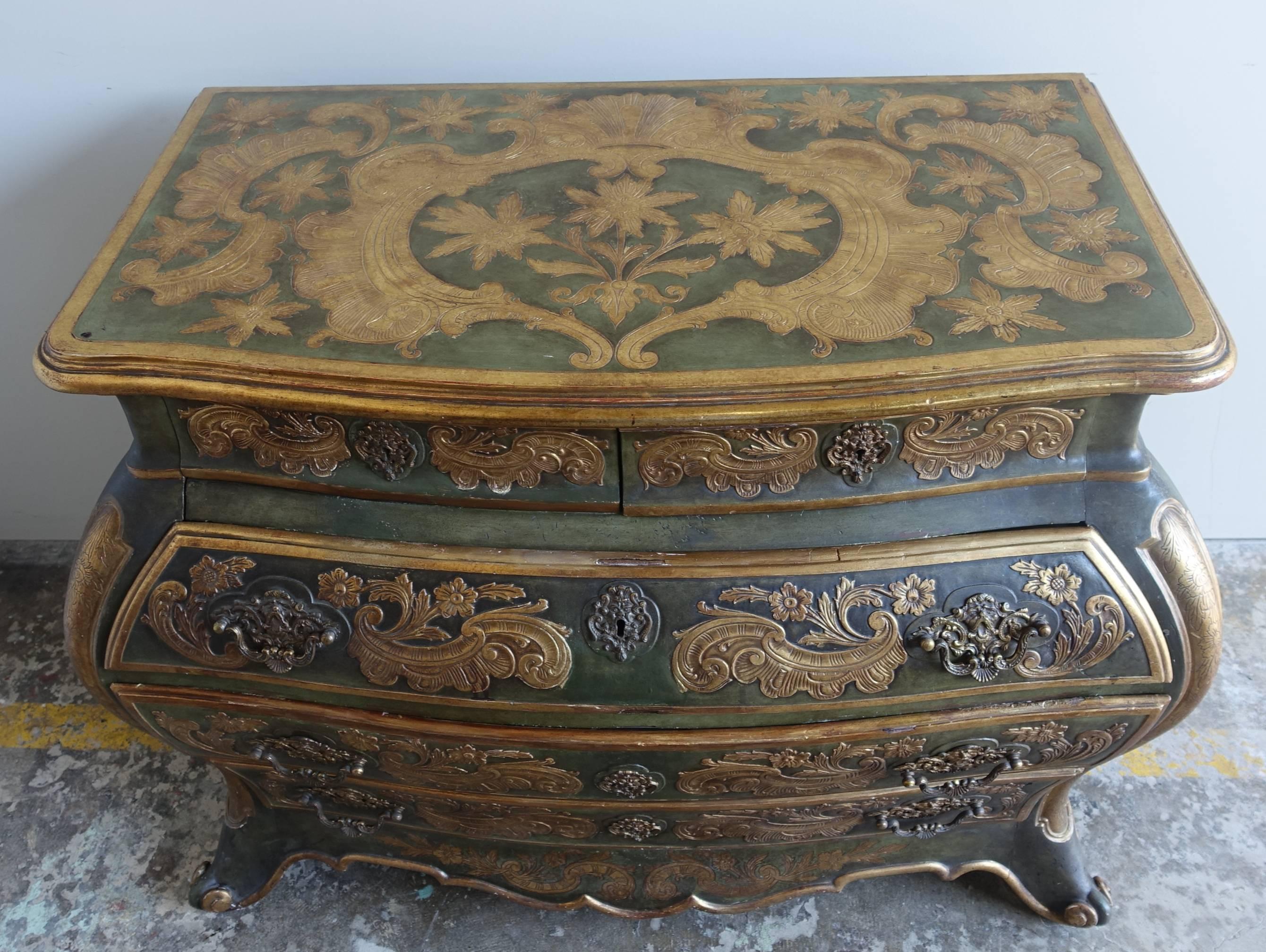 Italian wood painted gold gilt Bombay commode decorated with acanthus leaves and flowers throughout. The commode has five drawers standing on four legs with rams head feet. Beautiful original brass hardware.