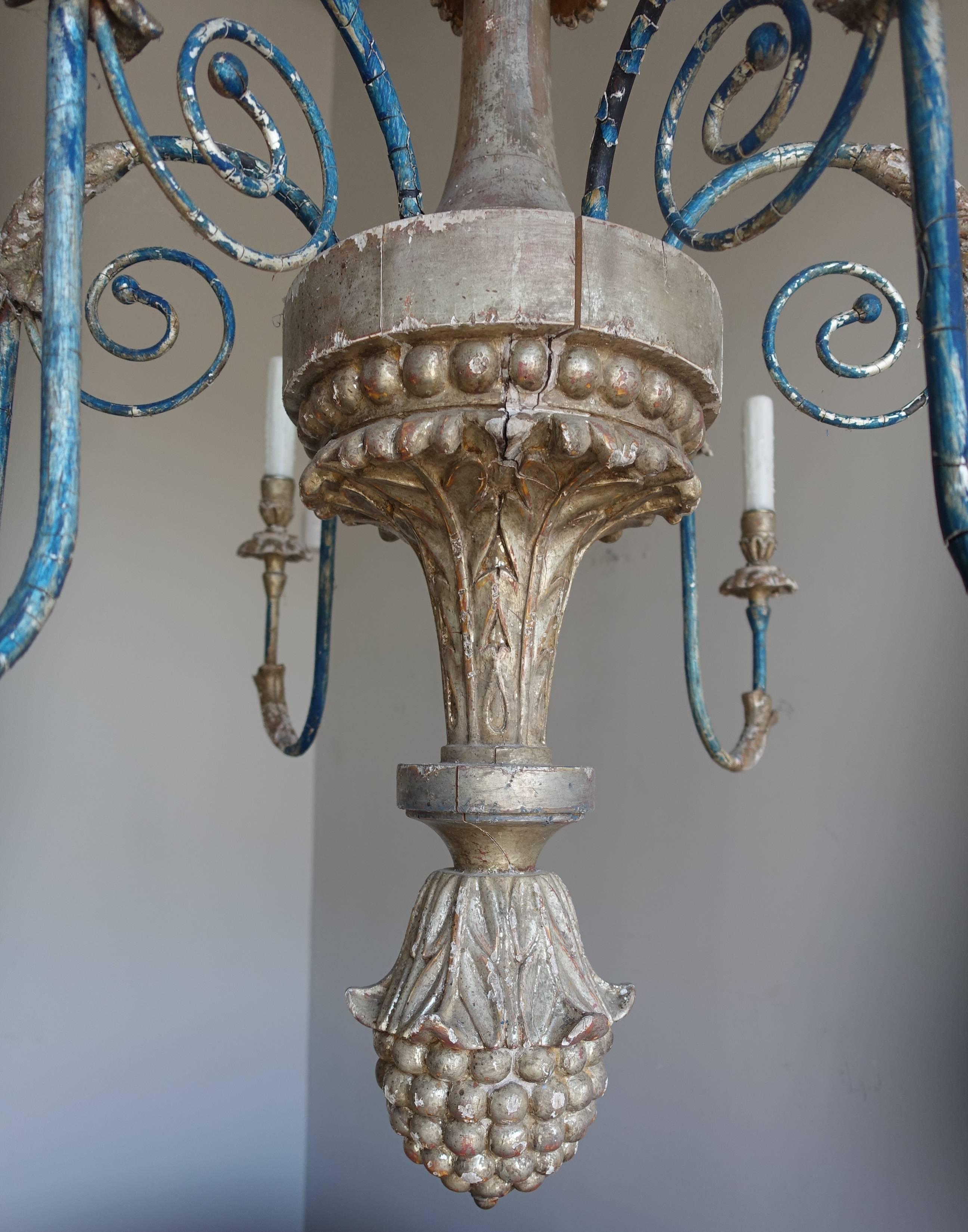 Six-light Italian carved silver gilt chandelier with blue painted wrought iron arms that have been newly wired with drip wax candle covers. Includes chain and canopy.