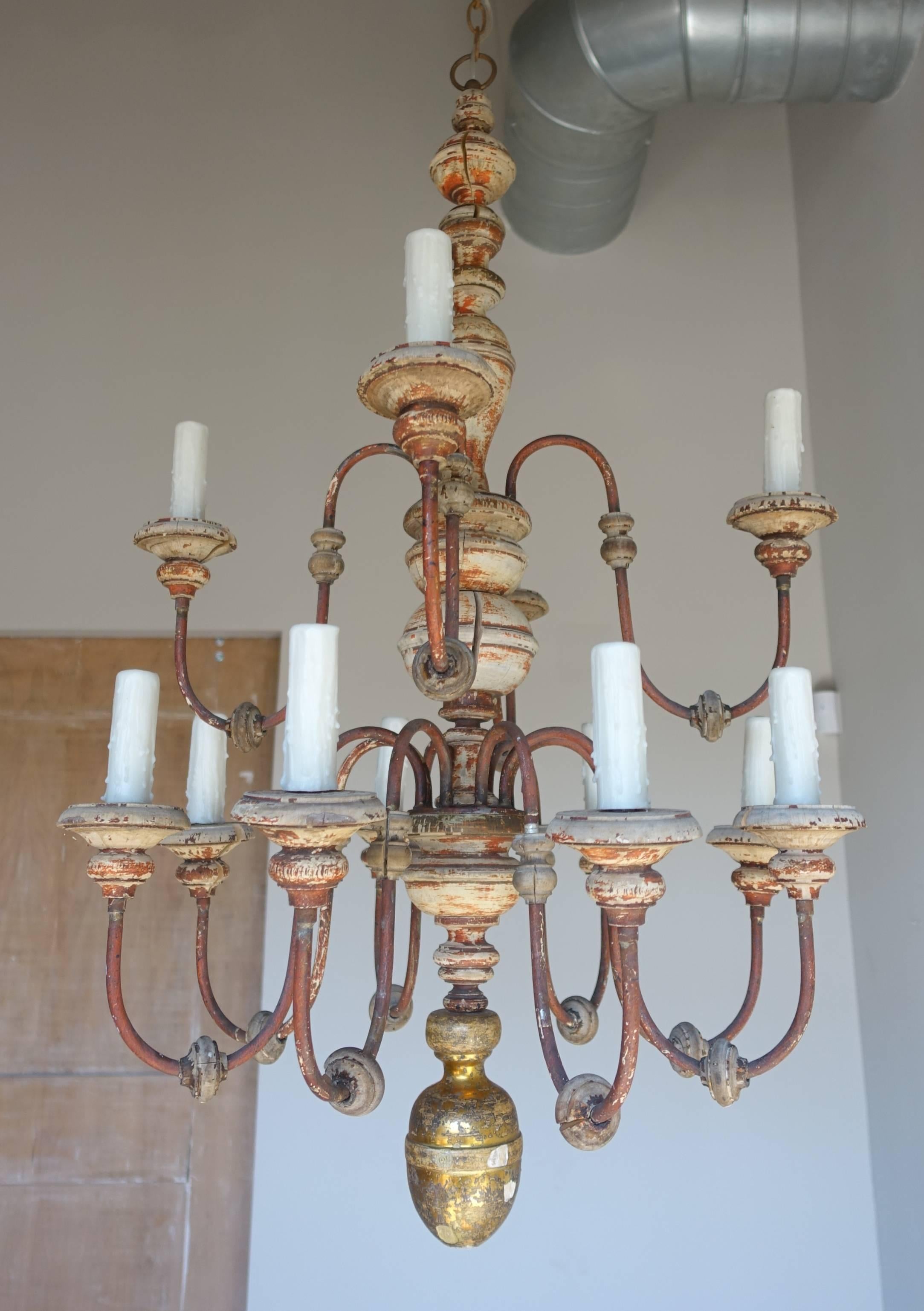 Twelve-light two-tiered Italian wood and iron painted and parcel-gilt chandelier. Newly rewired with drip wax candle covers. Includes chain and canopy.