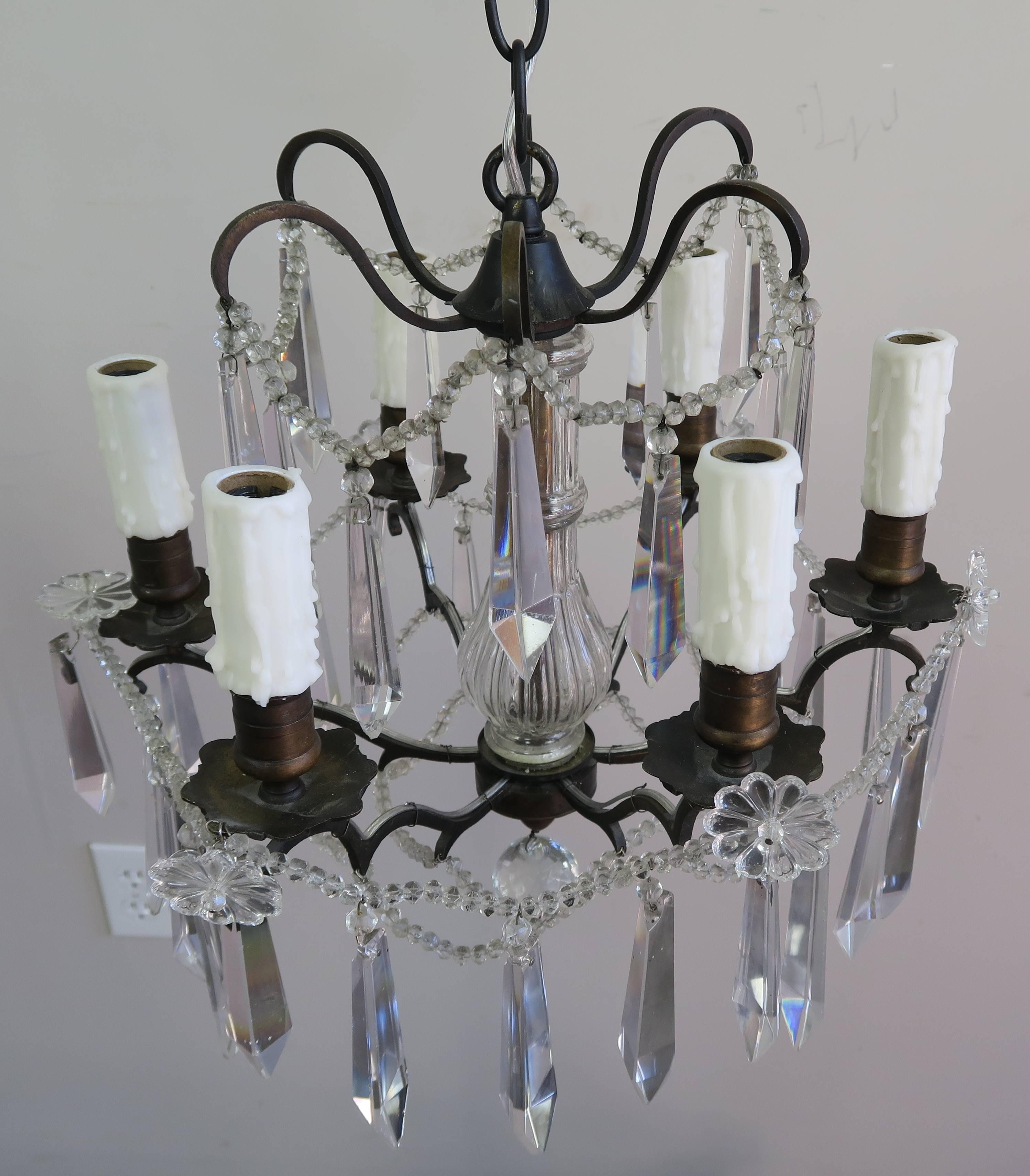 Pair of French bronze and crystal chandeliers newly rewired with drip wax candle covers. Includes chain and canopies.