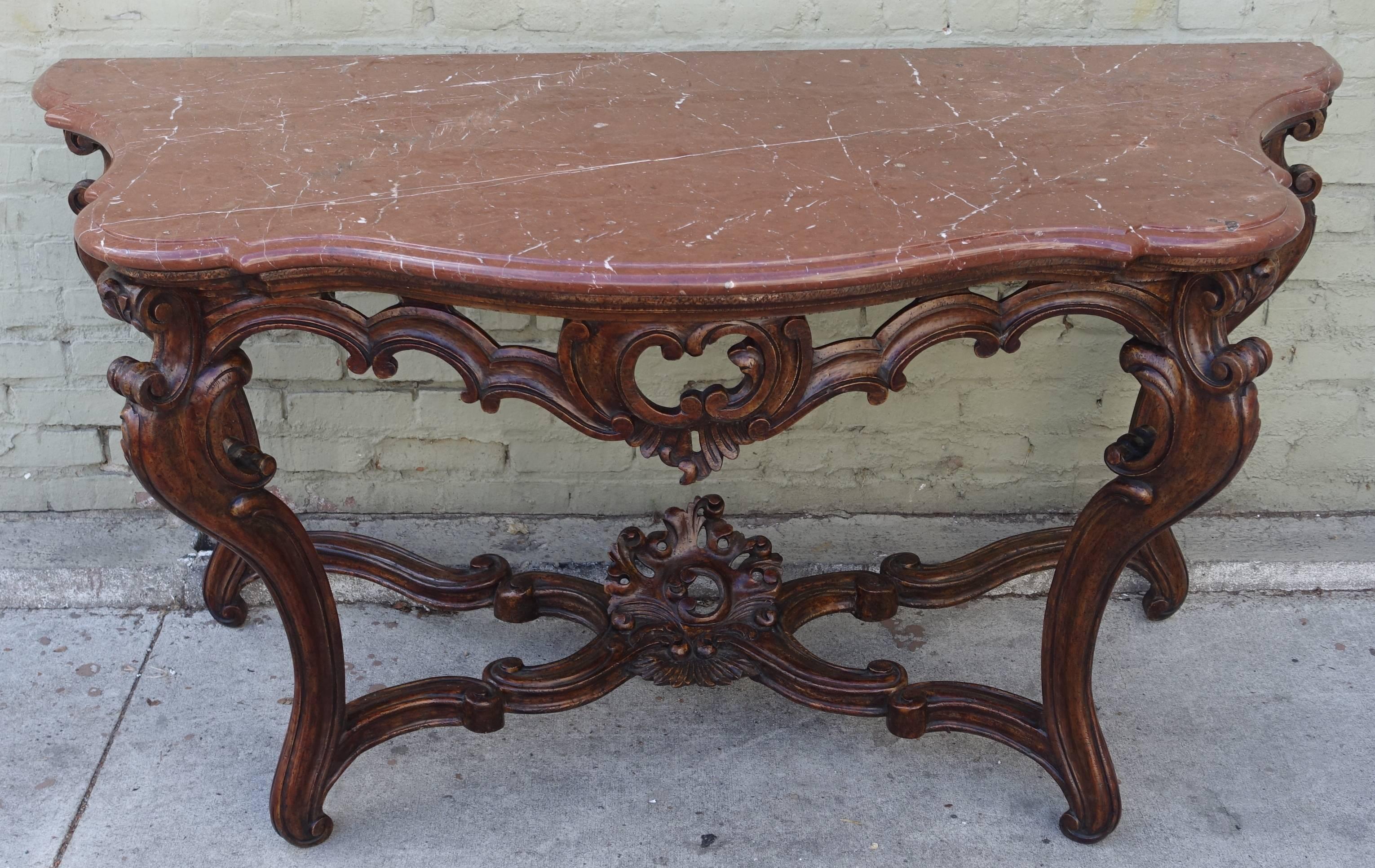 Pair of 19th century French serpentine carved walnut consoles with original marble tops.