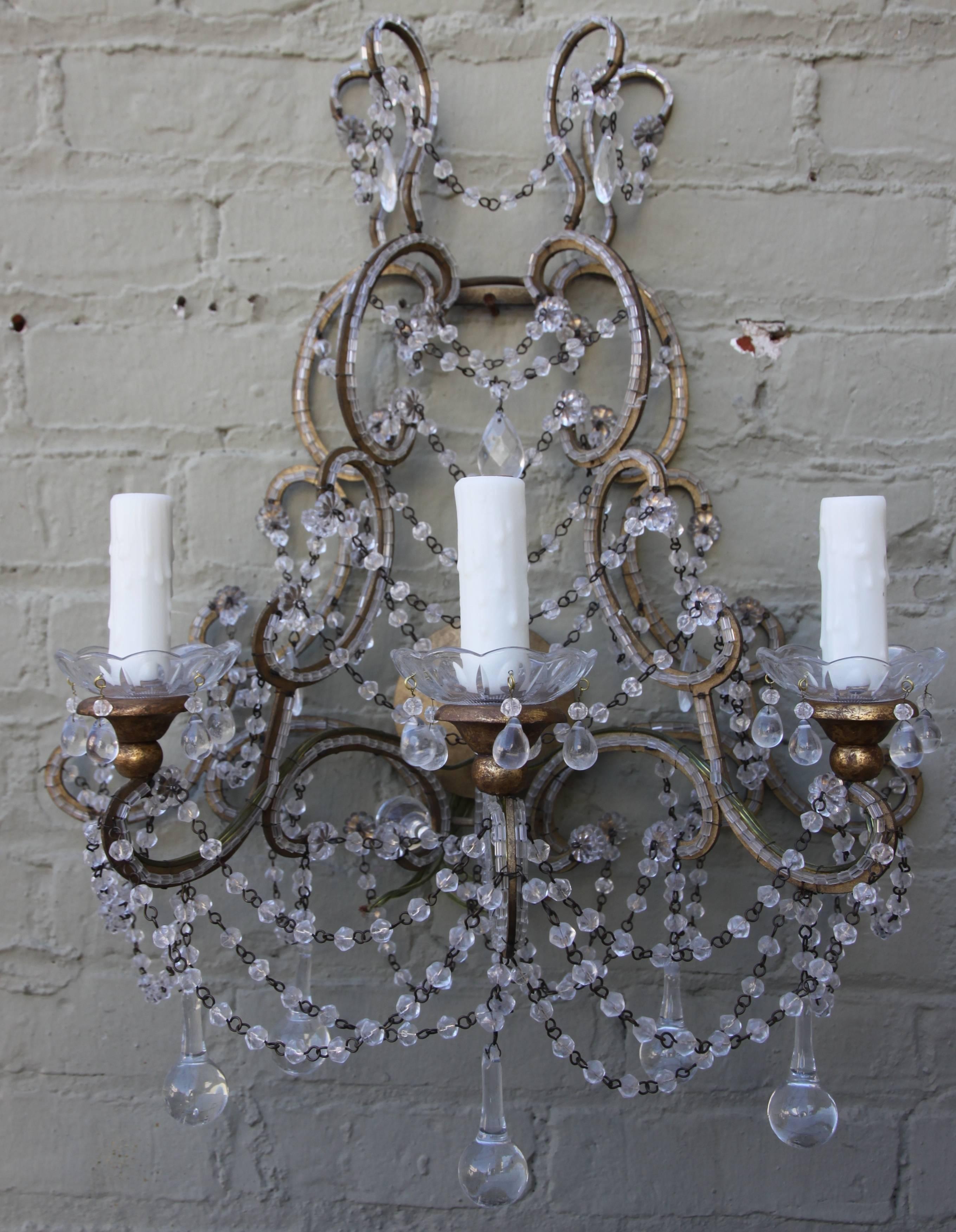 Pair of Italian three-light crystal beaded sconces with garlands of macaroni beads and clear drops throughout. The sconces have been newly rewired with drip wax candle covers.