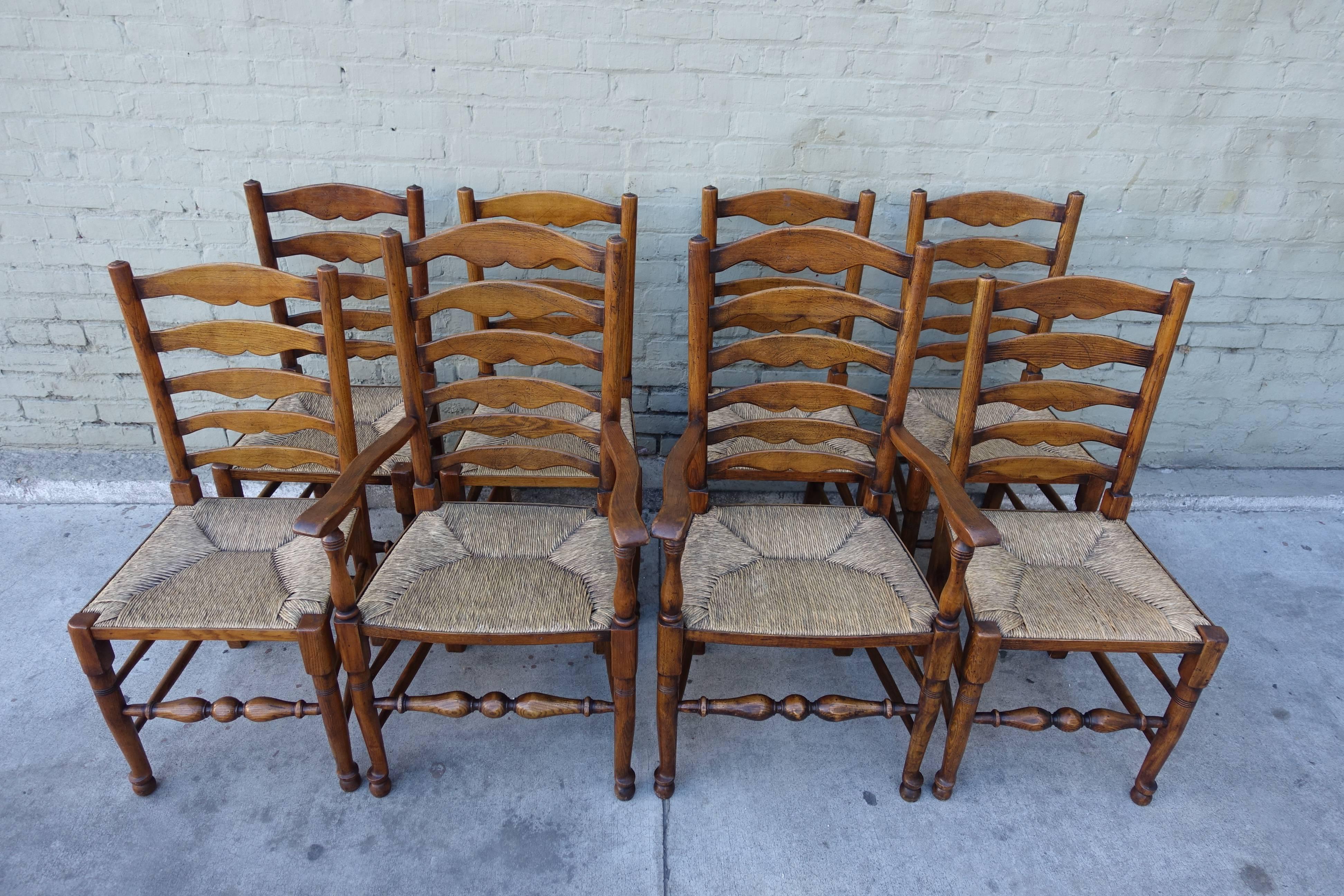Set of eight English ladder back dining chairs made from elmwood with rush seats.