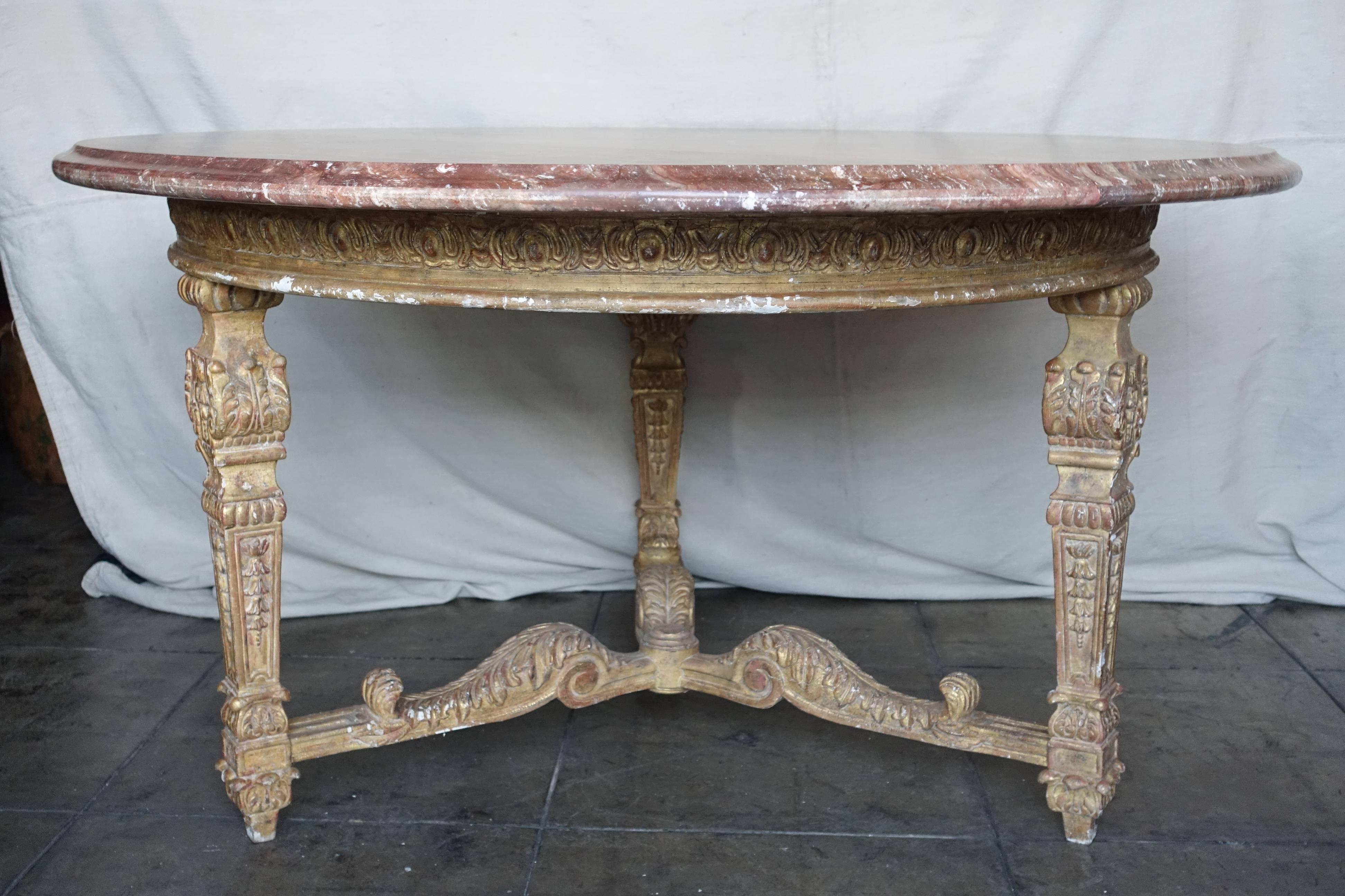 Italian 22-karat giltwood neoclassical style table standing on three straight legs that join together with a bottom stretcher. Marble top with ogee bullnose detail. Marble has repairs.