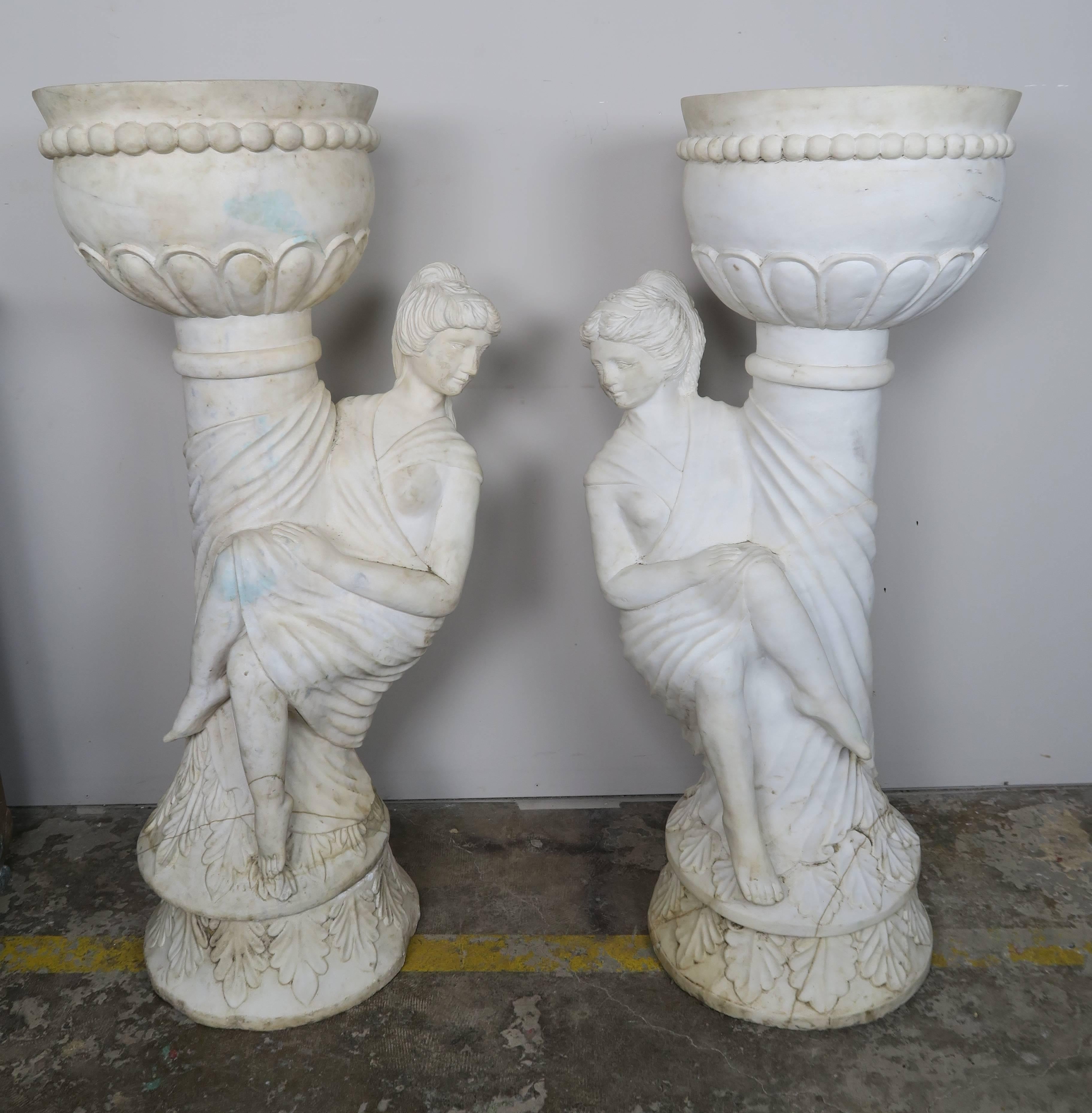 Pair of Italian Carrara marble figural planters of woman draped in classical Roman attire. Beautiful carved details throughout including carved acanthus leaves, beading and draped fabrics.