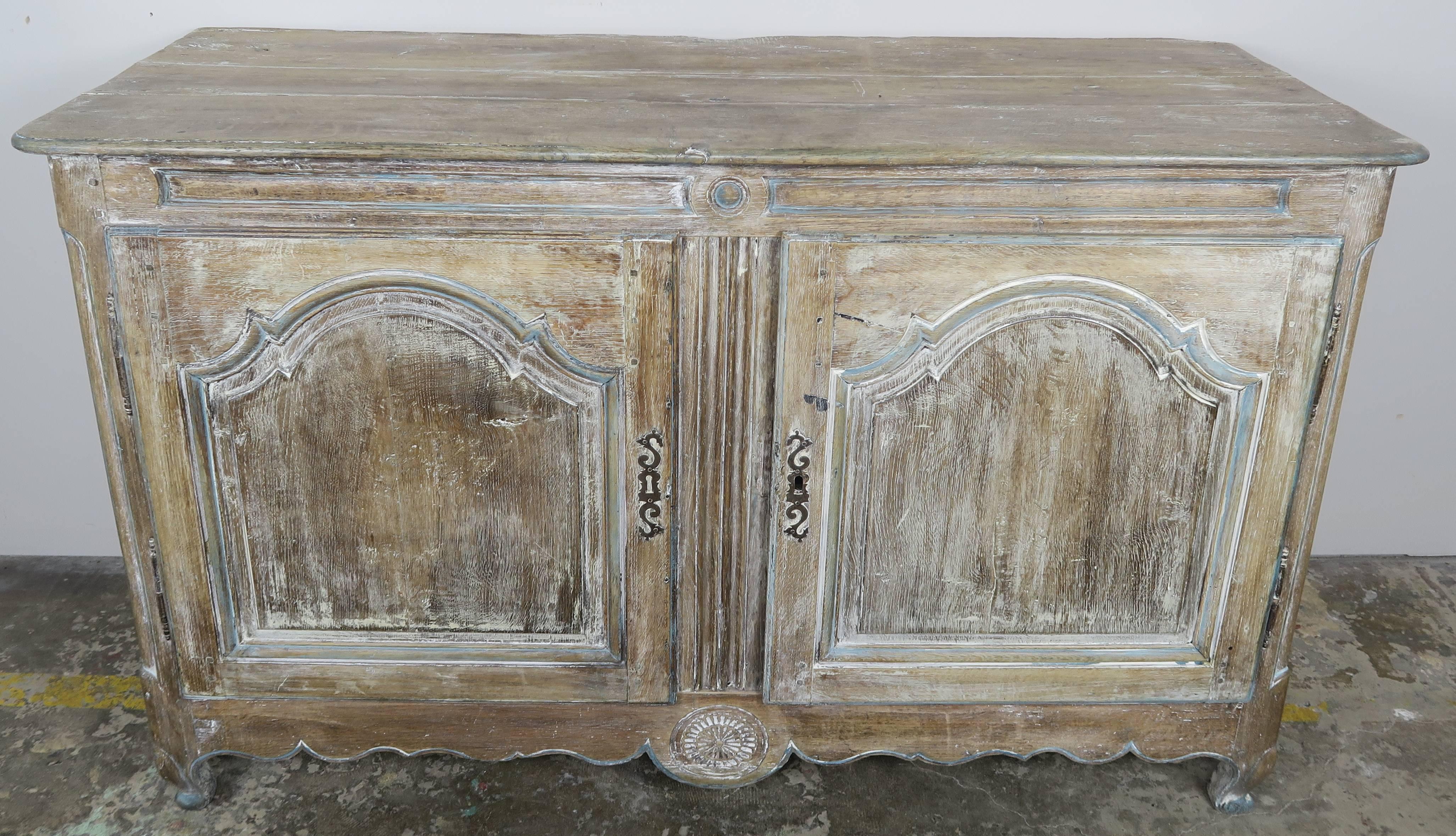 19th century French painted buffet with two doors. The piece stands on four cabriole legs with rams head feet. Beautiful worn finish with remnants of paint seen throughout.