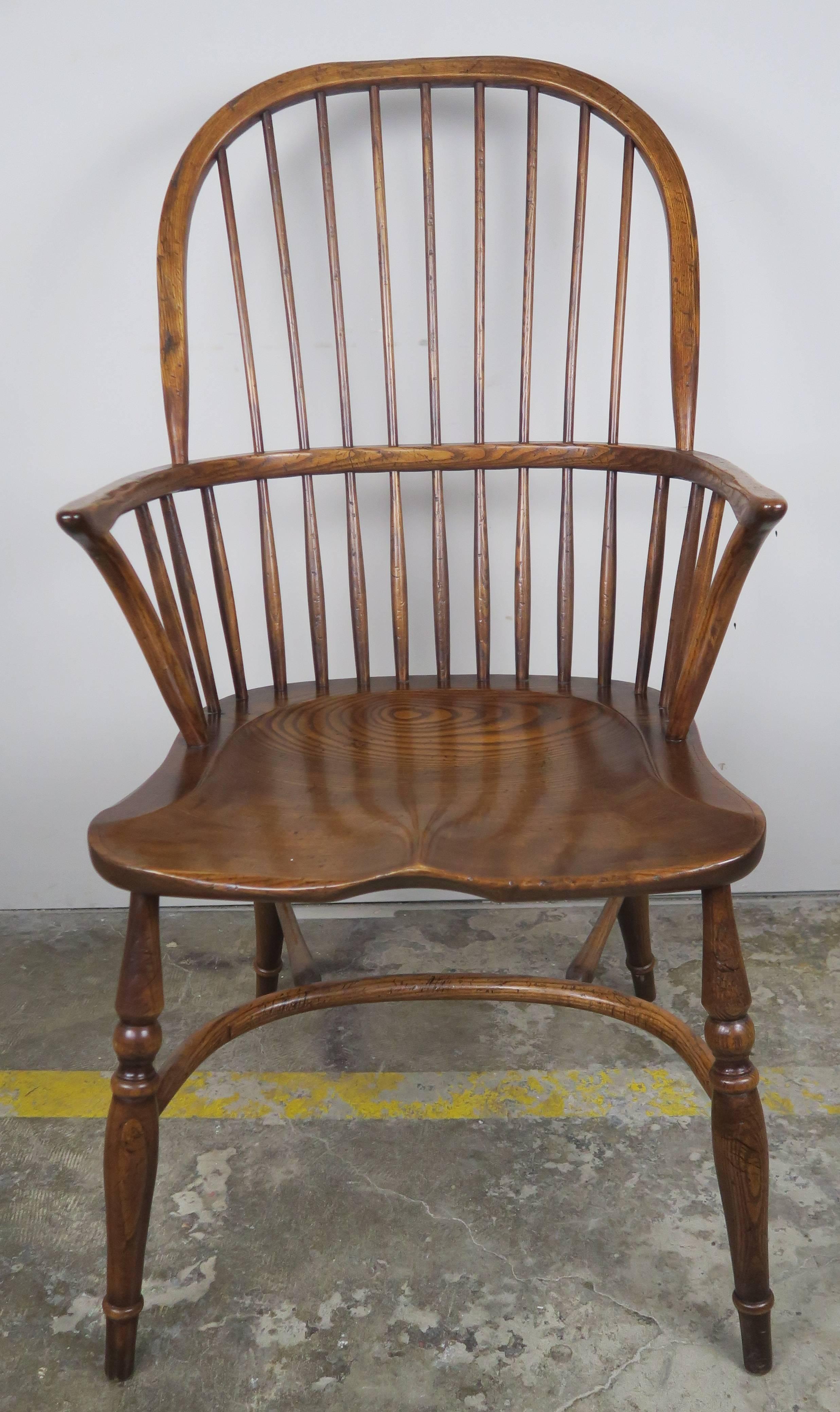 Set of eight American elmwood high bow-backed Windsor armchairs with exaggerated saddle seats and beautiful turned legs. The chairs include eight envelope filled seat cushions upholstered in a rust colored chenille textile.