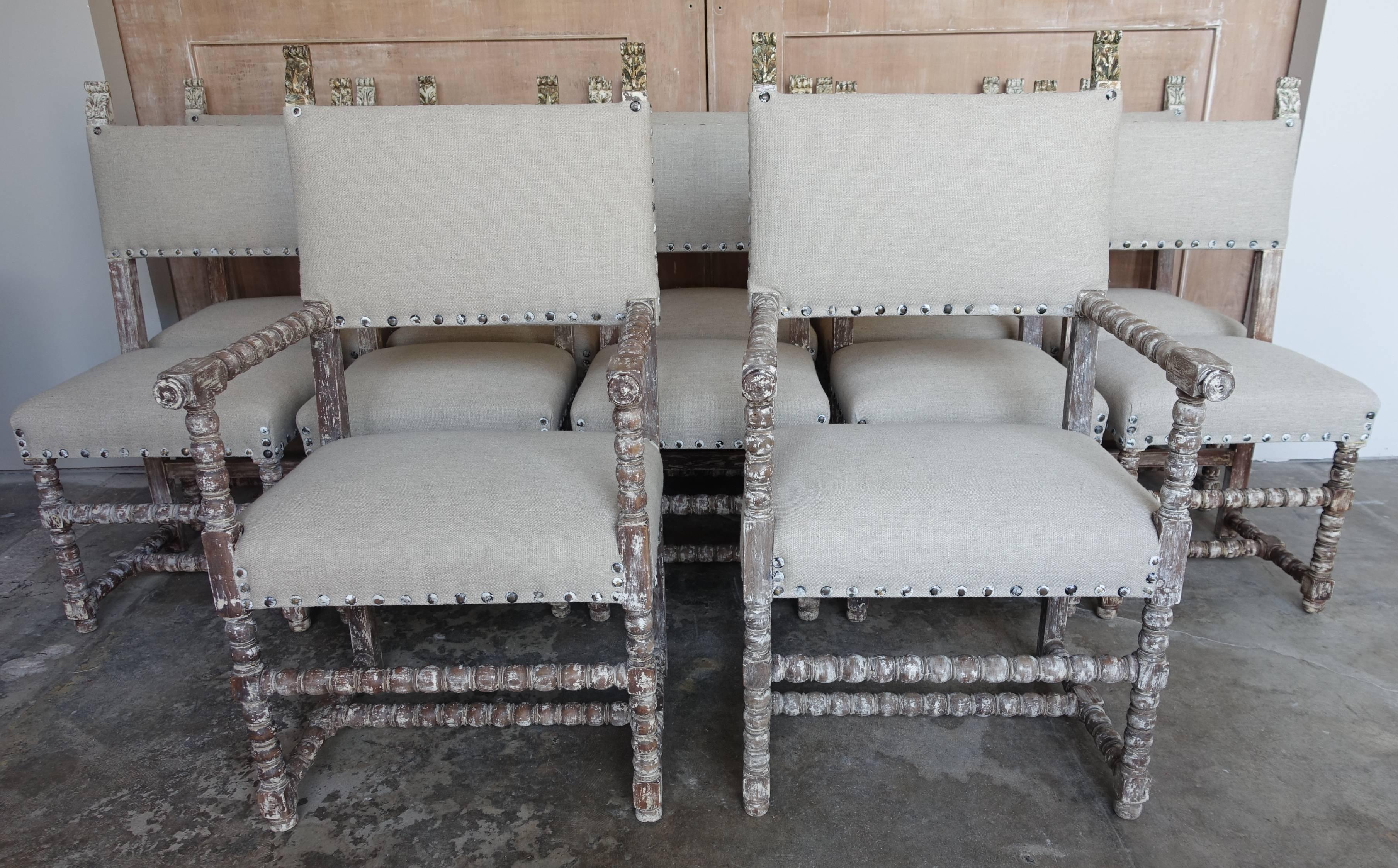 Set of (12) Swedish style painted dining chairs that have been newly upholstered in a natural textured linen. Spaced nailhead trim detail. 21