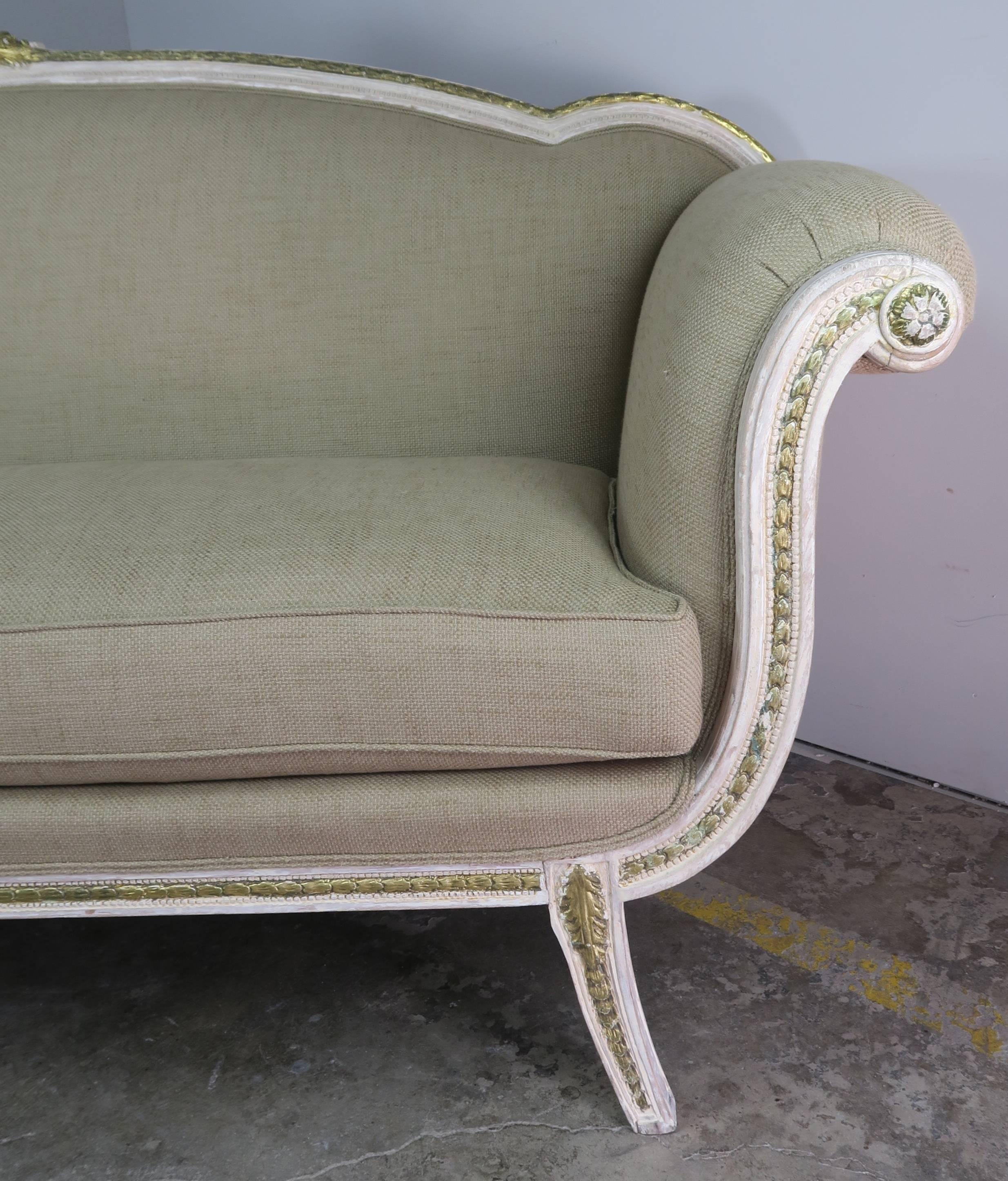 Italian carved wood painted and parcel-gilt sofa standing on four straight legs. The sofa has been newly upholstered in a textured linen with a loose seat cushion. Measures: 21