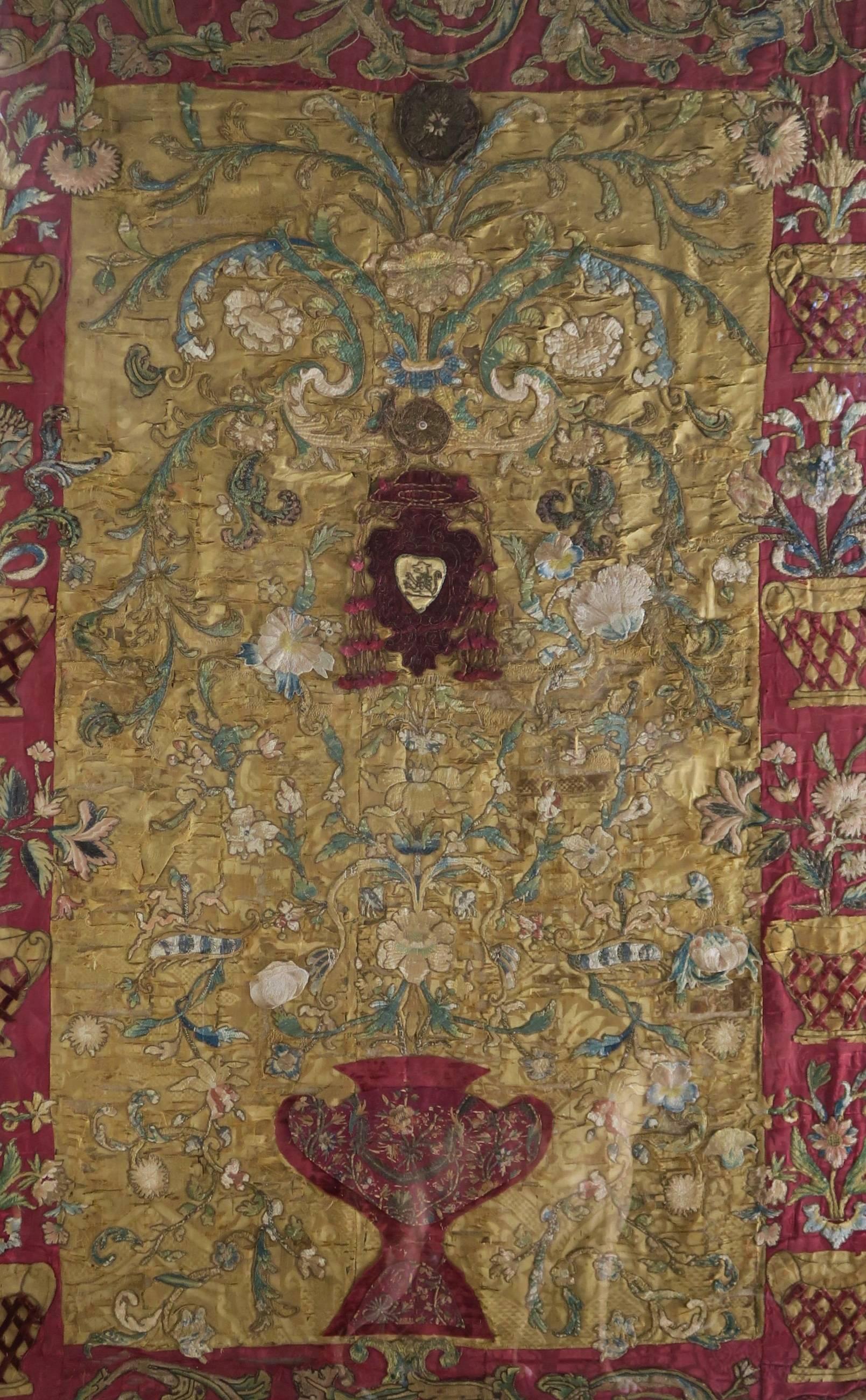 17th century framed Italian silk, metallic threads and velvet embroidered and appliqued textile in rich colors of red and gold with touches of aqua, pink, blue, rust, green and cream. There is also antique needlework in areas of the border. This