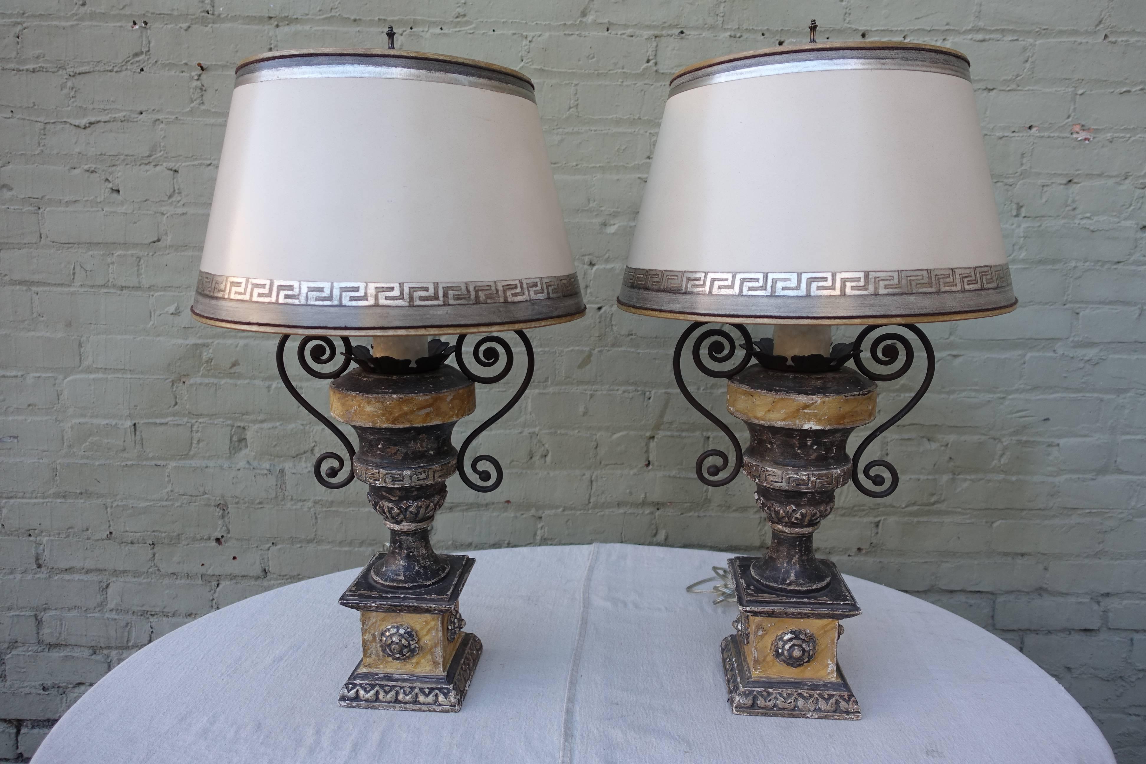 Pair of neoclassical Grecian style carved painted & silver gilt urns with carved Greek key design. The urn are newly wired into lamps and crowned with custom hand-painted parchment shades. Shade size: 12" diameter. top X 17" diameter.