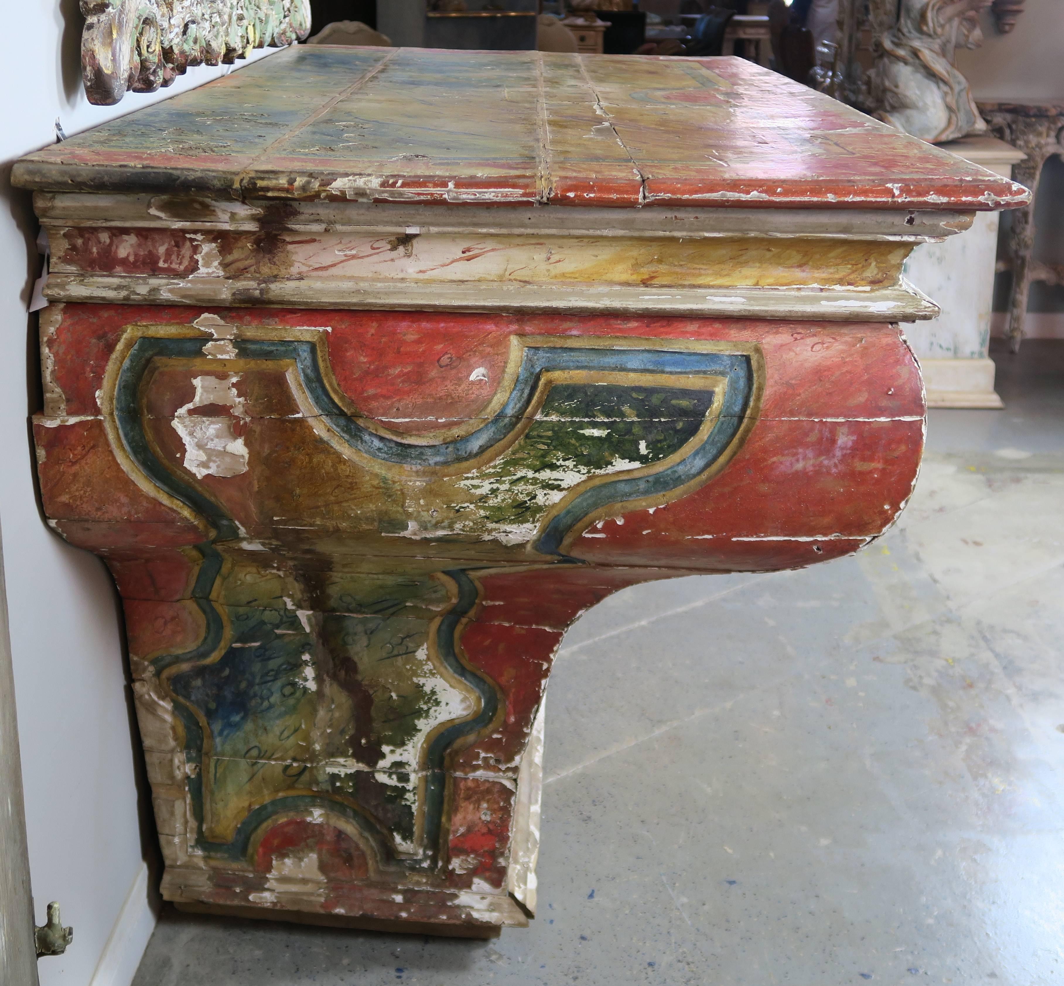 Early 19th century faux painted Spanish altar table in rich shades of blues, greens, and faded red. Worn paint with gesso showing underneath.