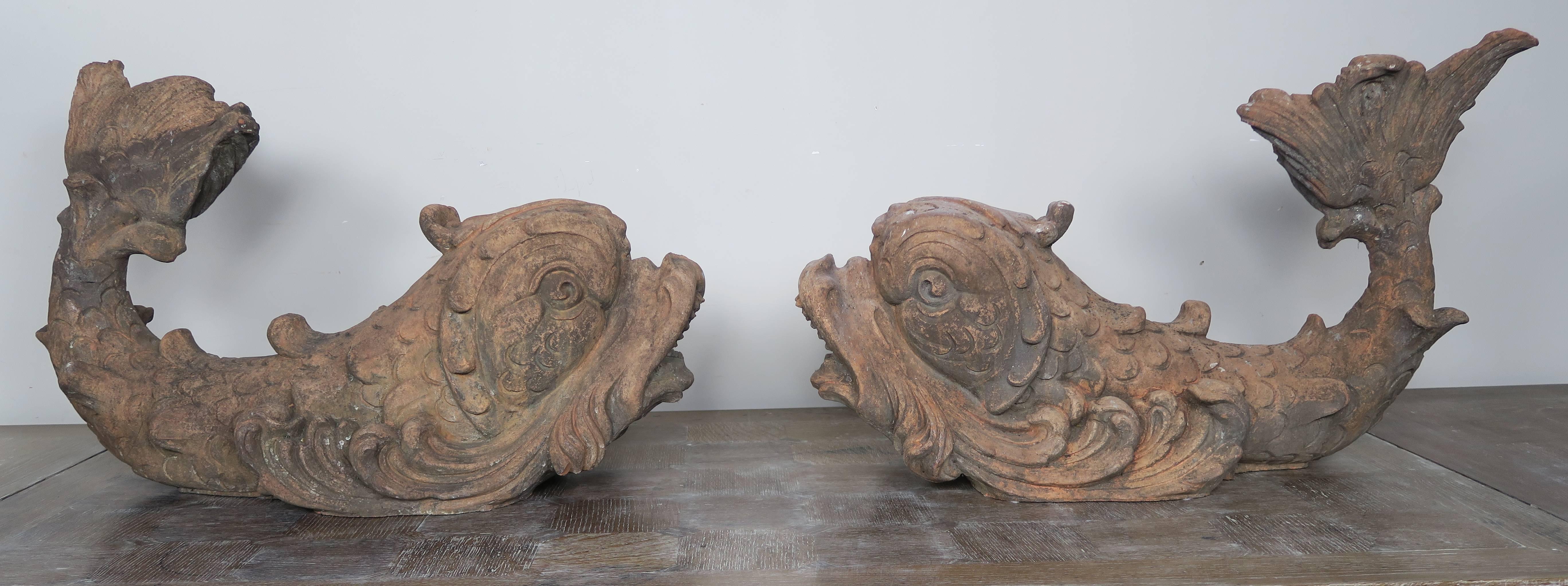 Pair of early 20th century Italian Monumental terra cotta dolphin fountains. Manufacturers stamp on bottom. Old repair on tail.