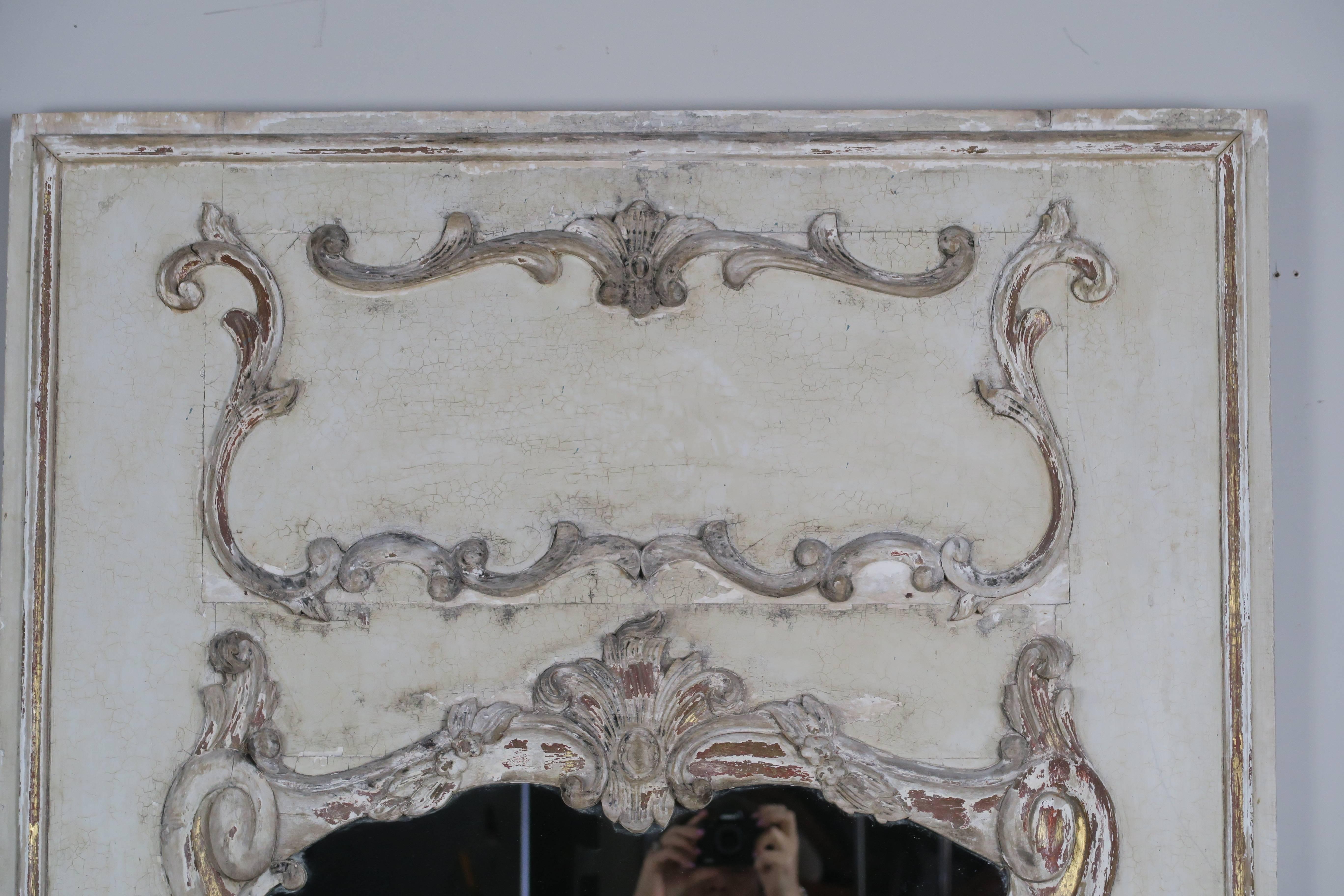 French painted and parcel-gilt mirror in soft cream coloration with gold leaf remnants throughout.