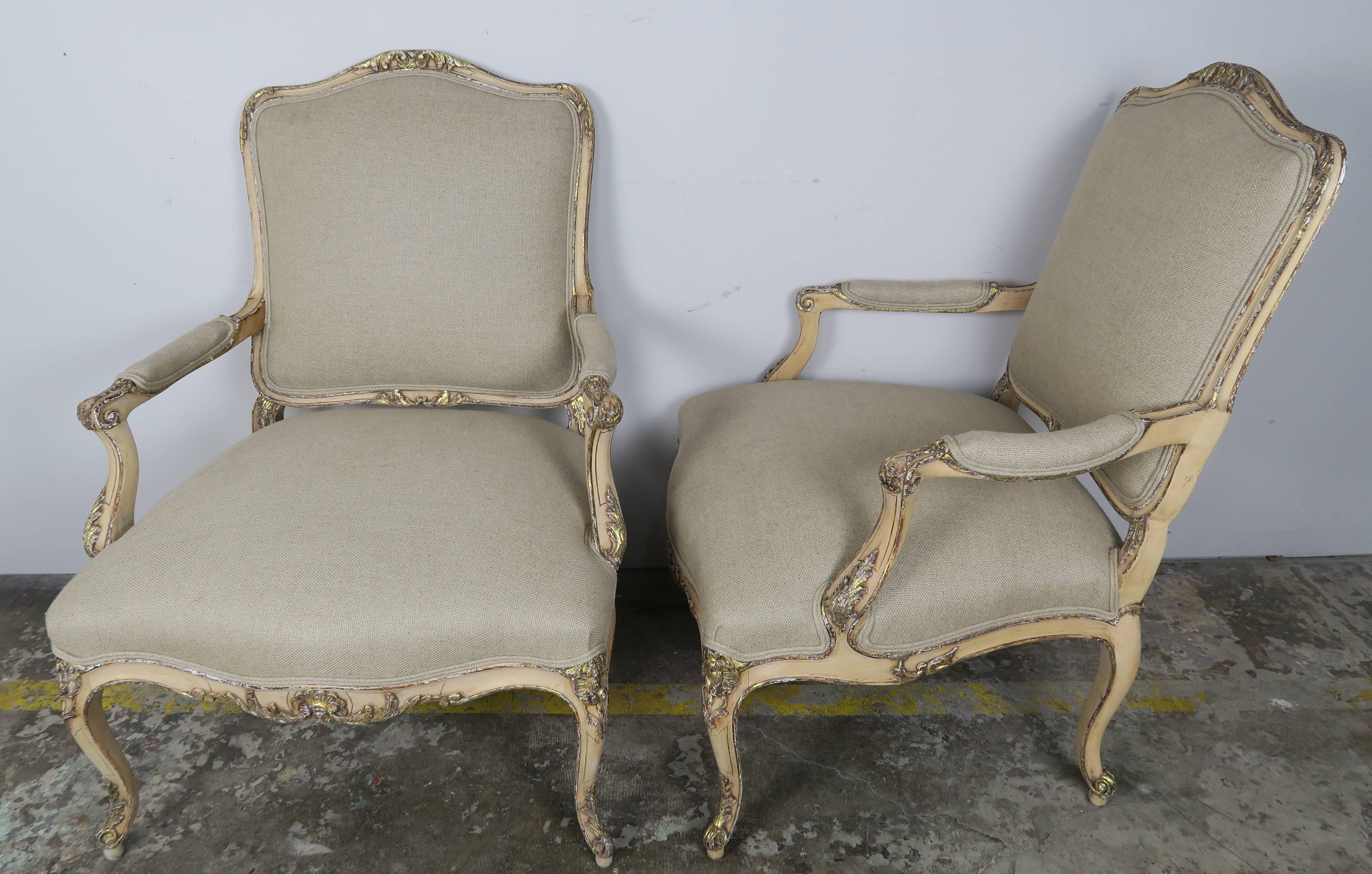 Pair of French carved Louis XV style natural walnut and parcel silver gilt armchairs standing on cabriole legs with ram's head feet. Newly upholstered in a Belgium linen with double self cording.