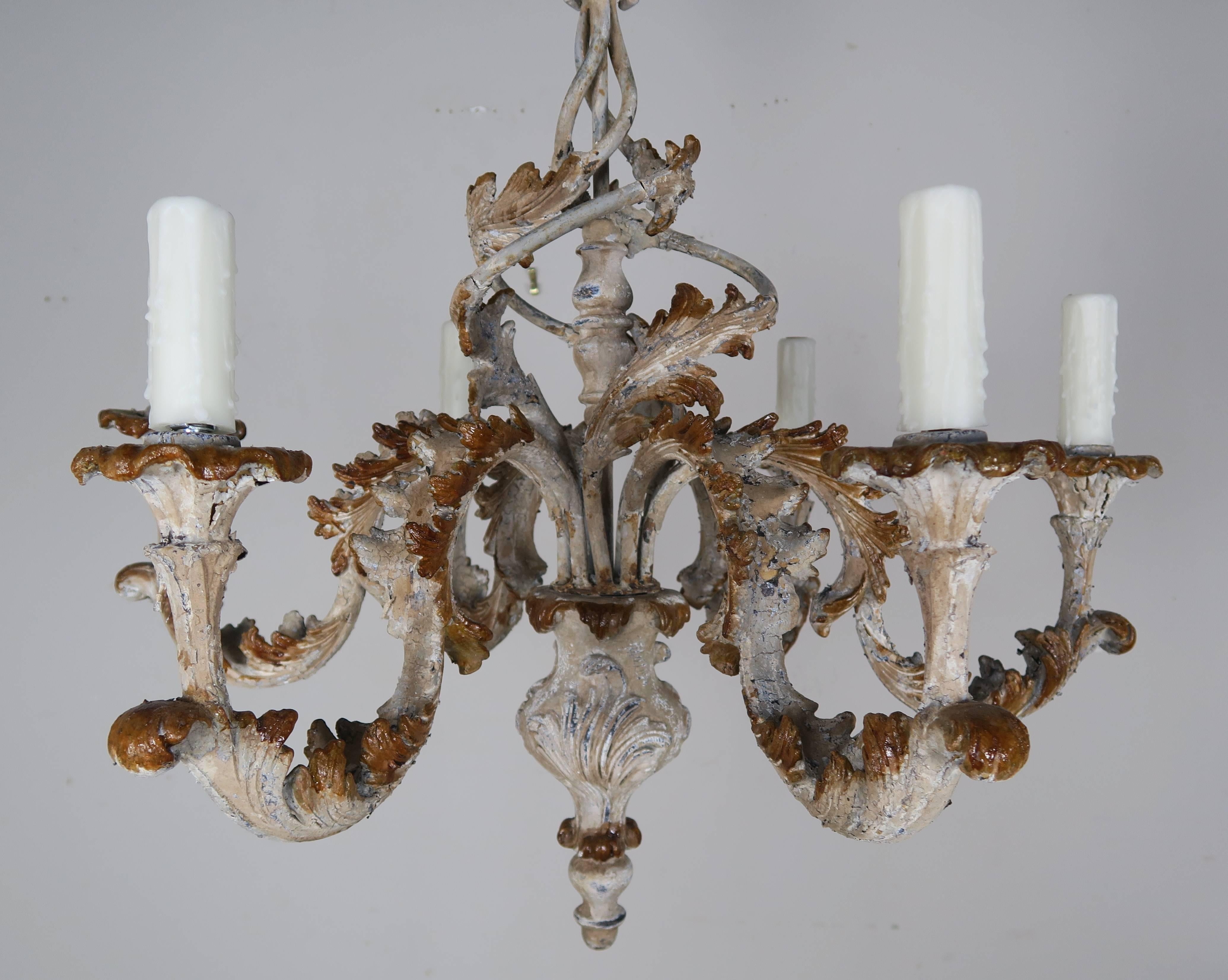 Pair of Italian carved wood painted six-light chandeliers with swirling acanthus leaves throughout. The chandeliers are newly rewired with drip wax candle covers. Chain and canopies included.