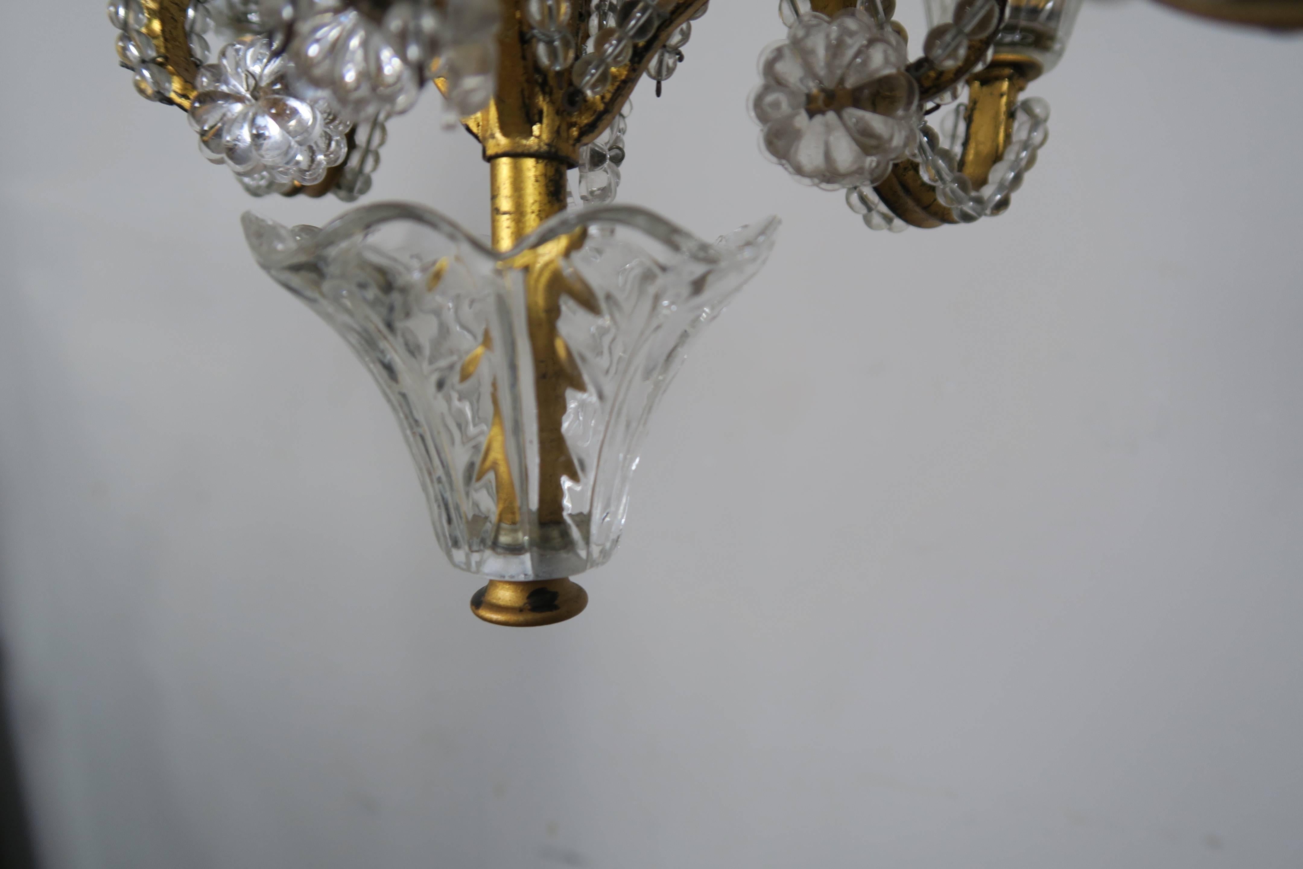 Gilt metal and crystal beaded four-light chandelier. Includes chain and canopy.