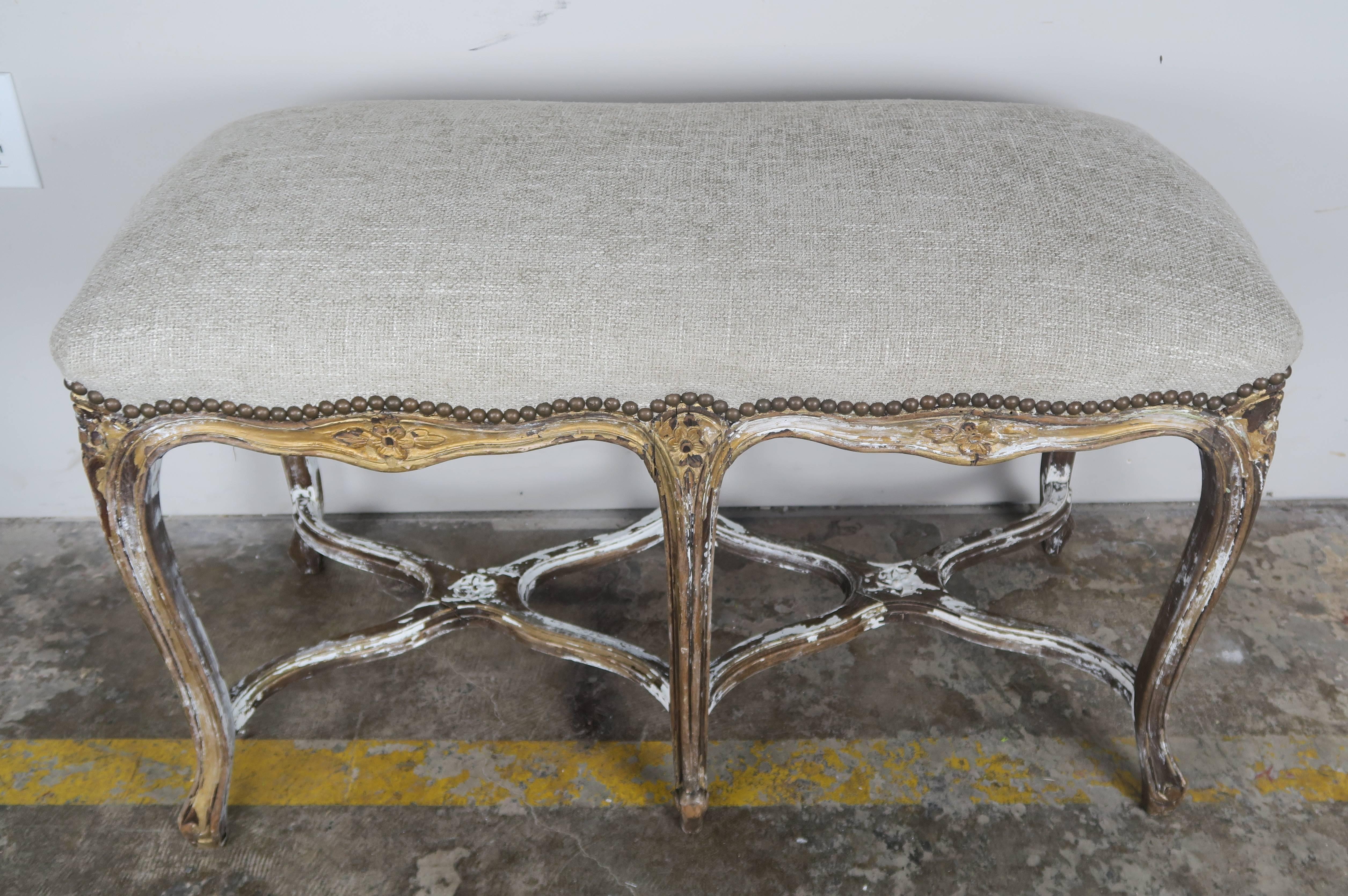 19th century carved giltwood Louis XV style bench standing on six cabriole legs with reams head feet and double 