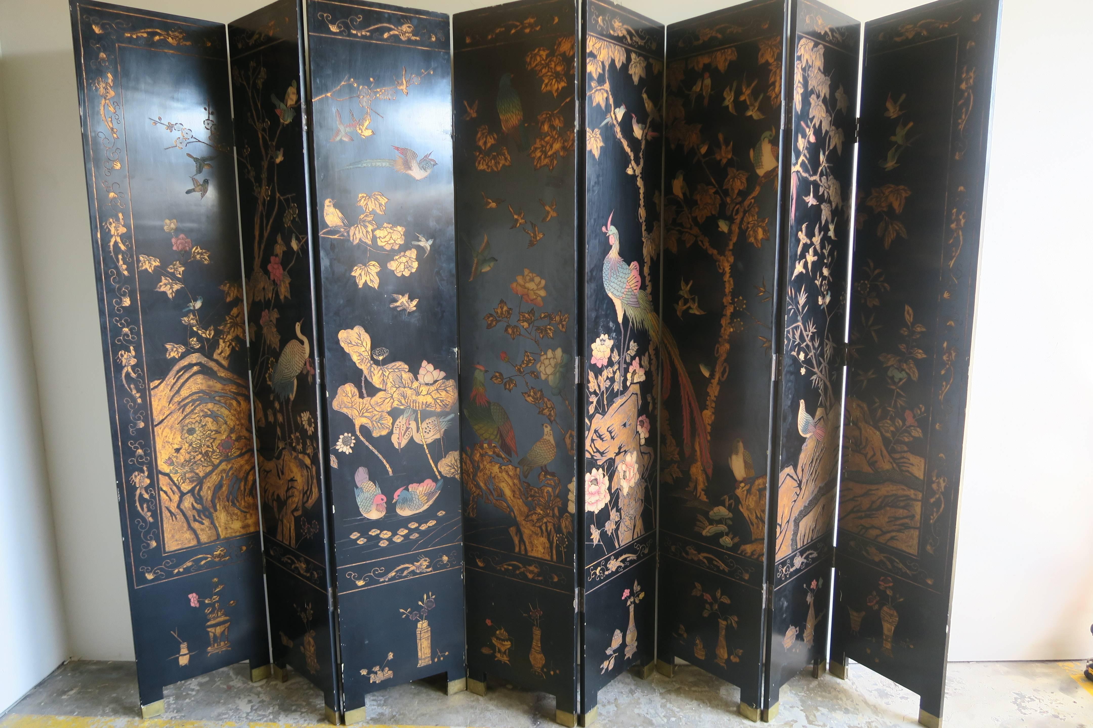 Monumental Chinese eight-panel folding Coromandel screen with double sided decoration. Featuring thick layers of lacquer incised with gold leaf and painted decoration depicting a variety of birds in a floral garden. Reminiscent of the large gilt