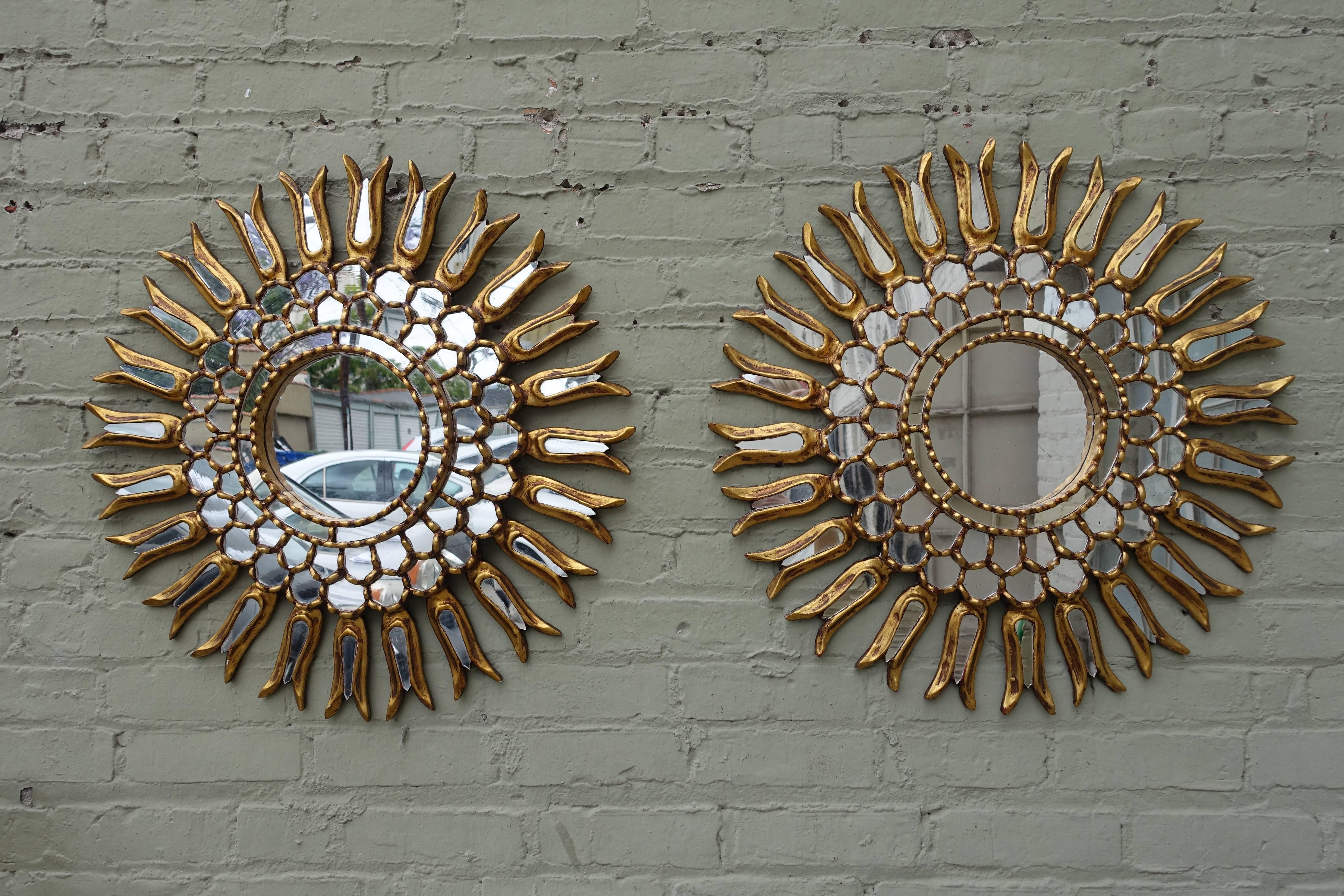 Pair of 1930s Spanish gold leaf sunburst mirrors with small mirror insets throughout the outer rays and outer circle.