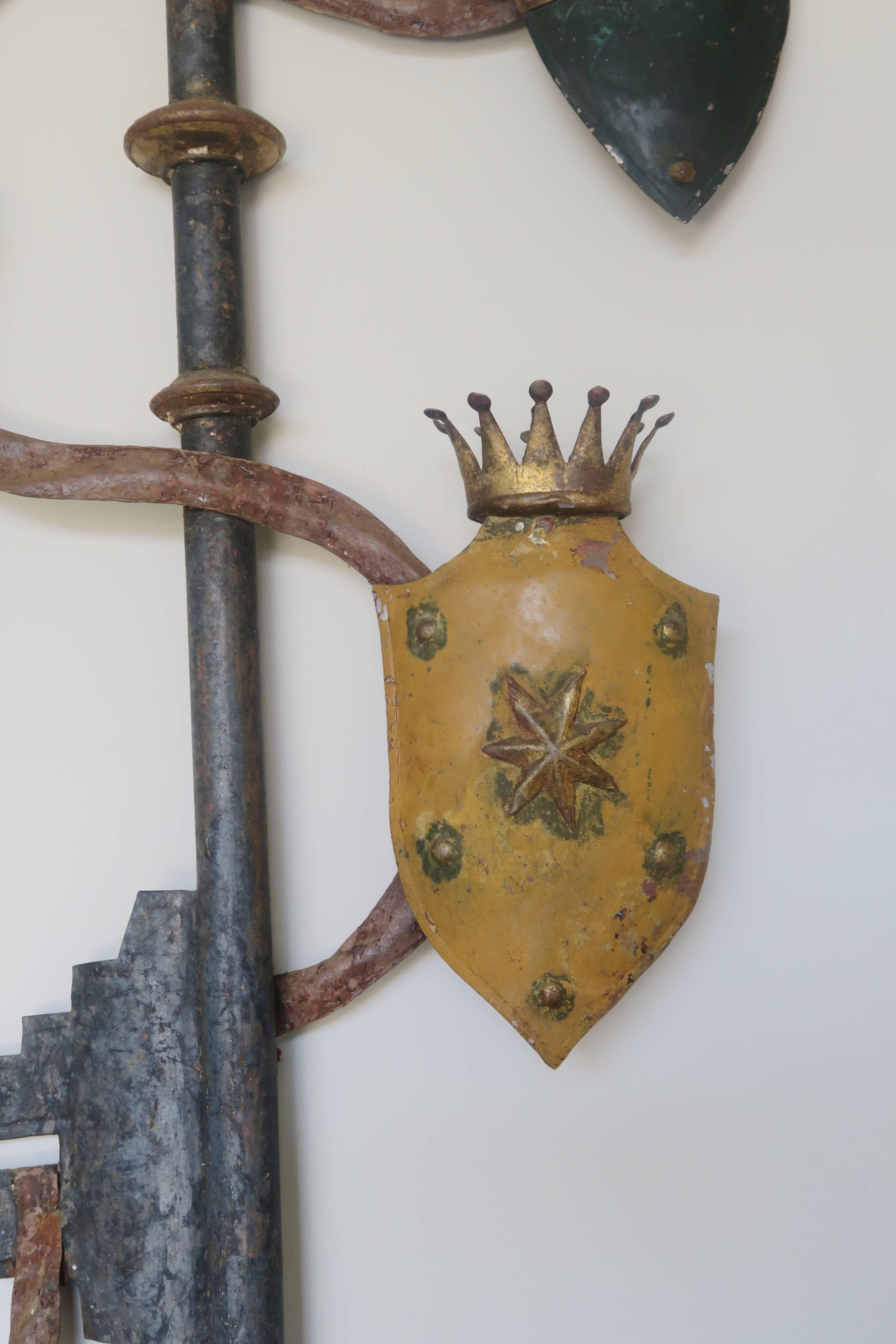 English painted and parcel-gilt tole metal key with crowned shields twisted though out. Great wall decor.