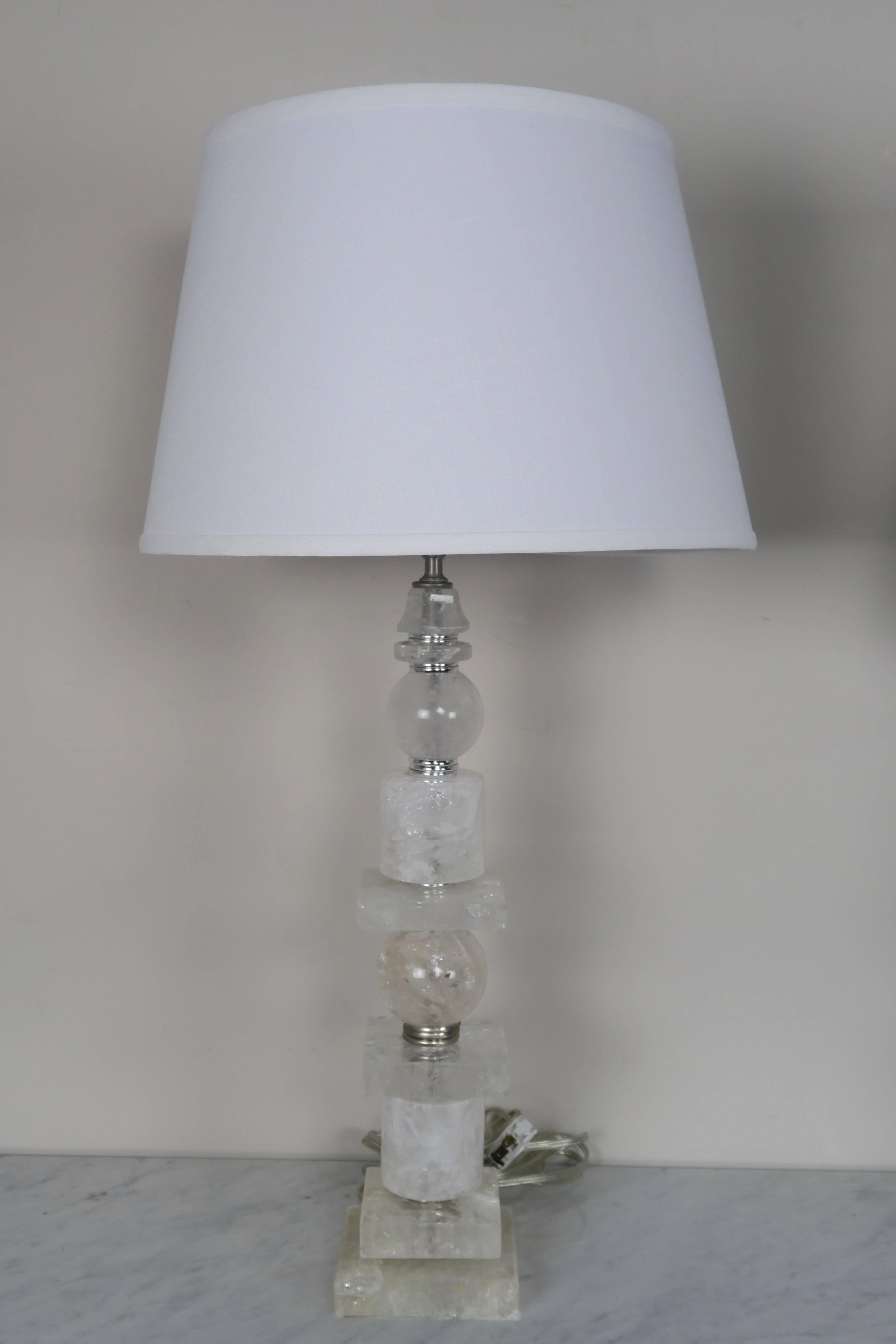 Pair of sculptured rock crystal quartz and polished nickel lamps. The lamps are finished with custom white linen shades. The lamps are newly rewired and ready to use.