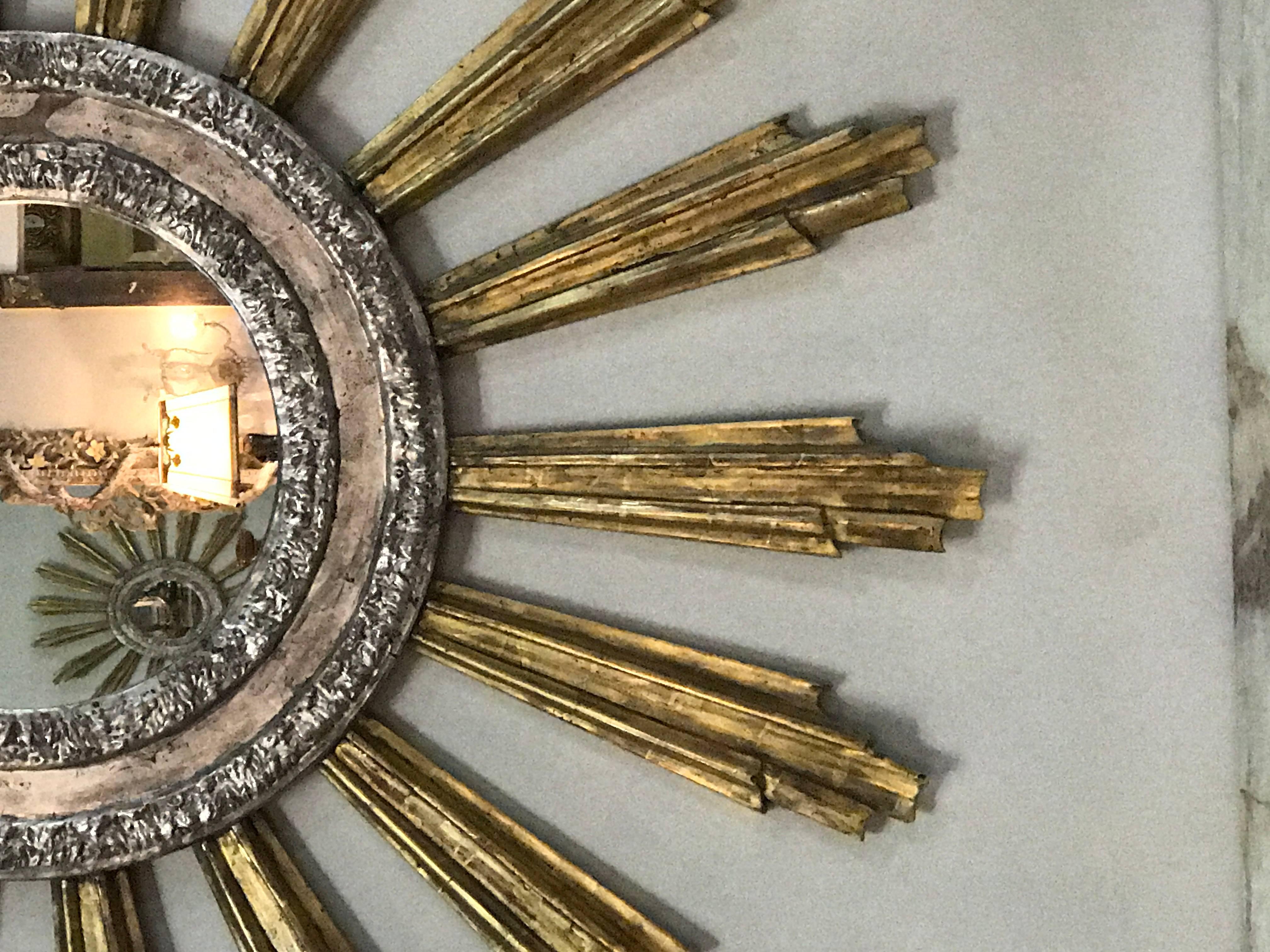Monumental Italian silver and gold leaf sunburst mirror. A great statement piece for any room!