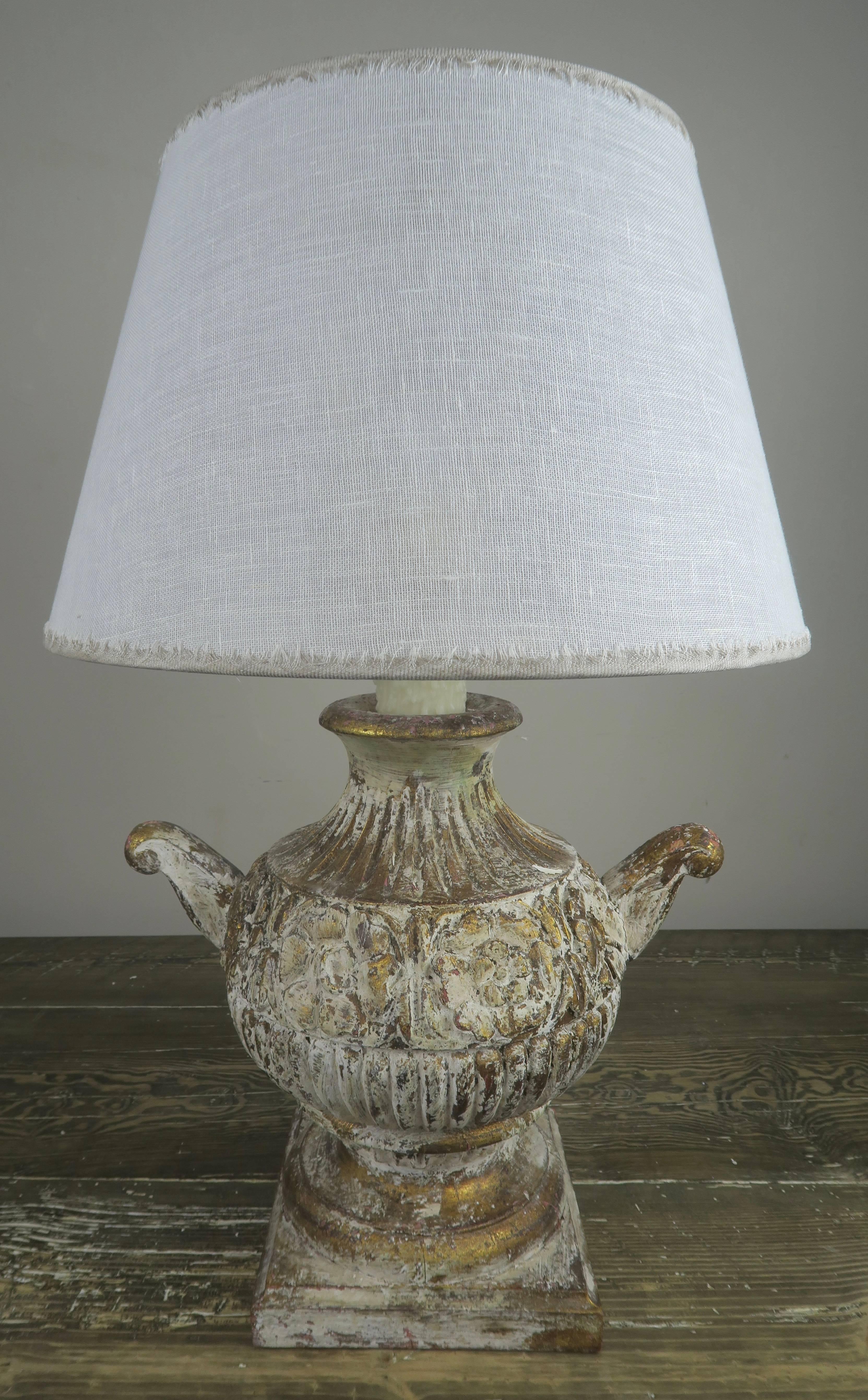 Pair of carved Italian antique white with gold painted urn lamps with custom linen shades.
Linen shade size: 12