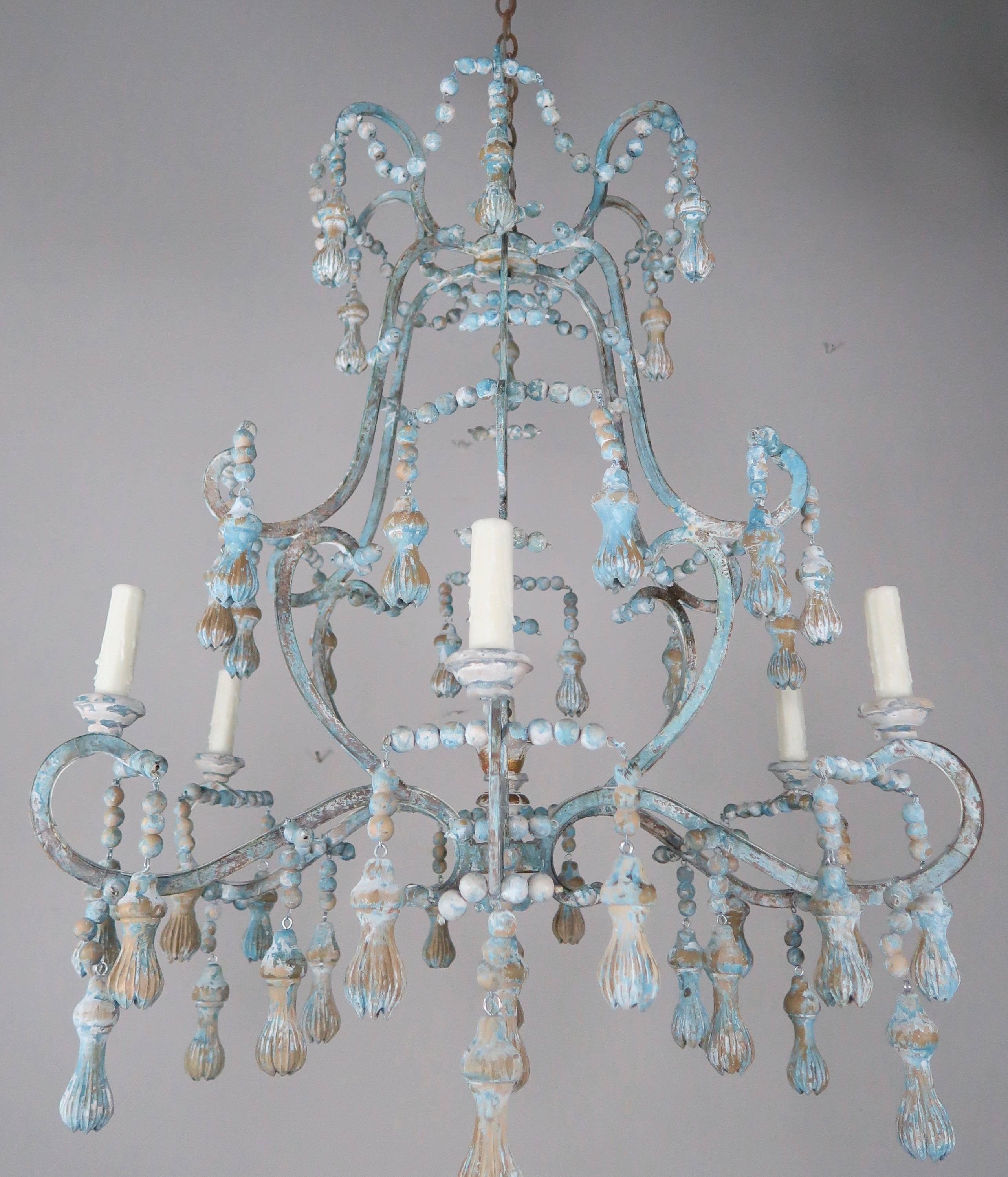 Six-light Italian carved wood beaded and iron chandelier with giltwood centre finial and tassel drops throughout. Newly wired with drip wax candle covers. Includes chain and canopy. A pair is available if needed.